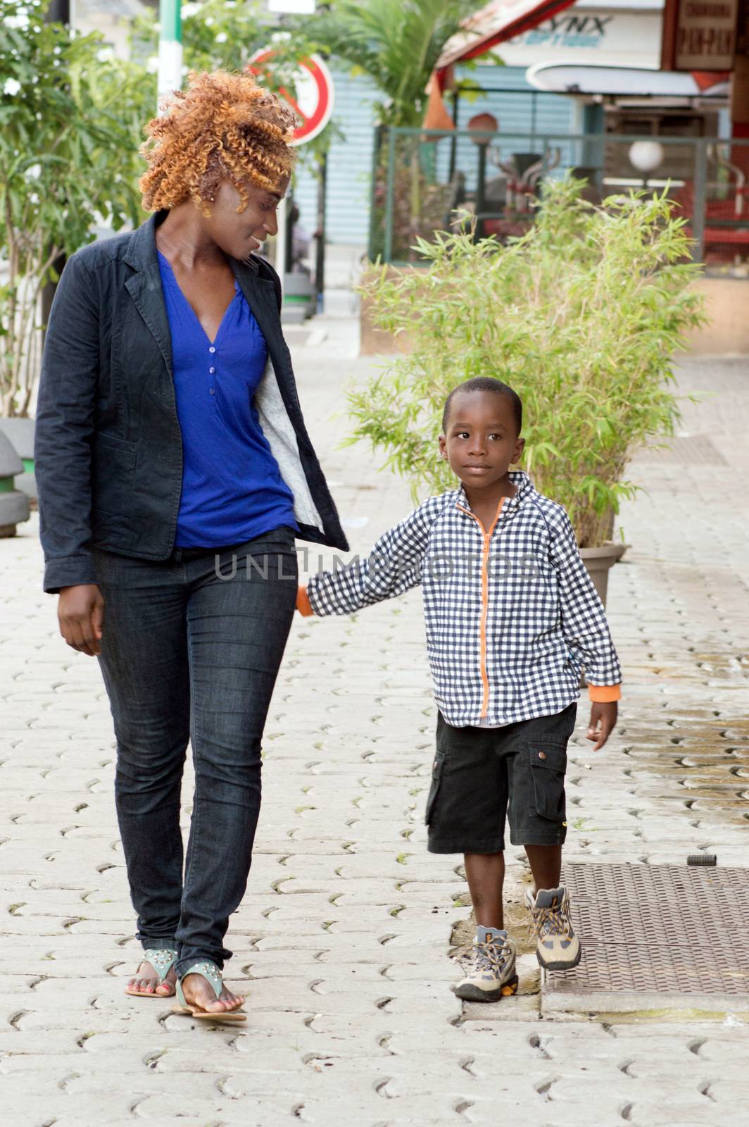 young woman walks with her little boy by talking to different places visited.