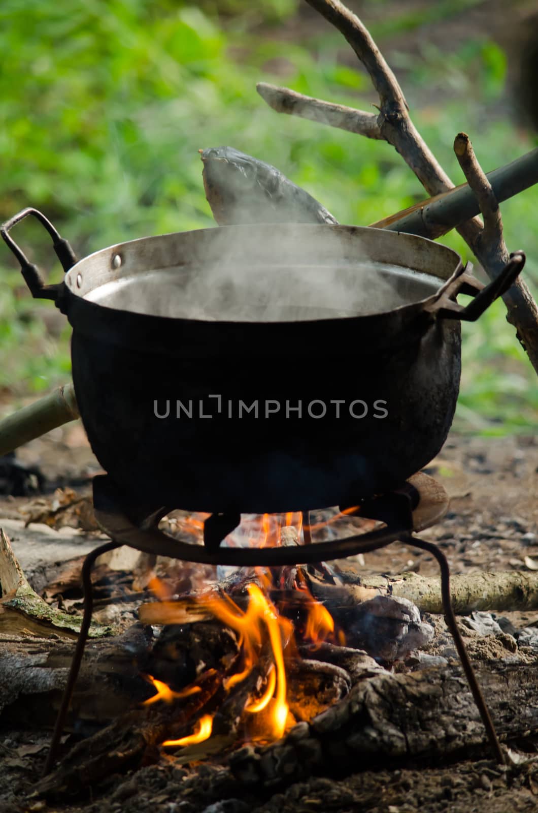 the bonfire is burning firewood under pot