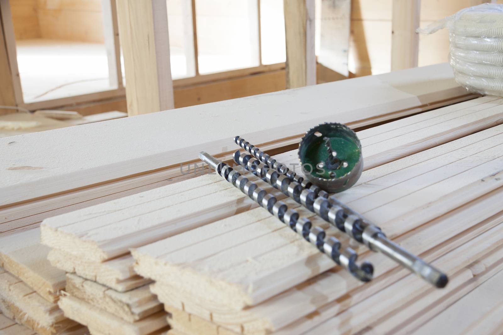 Different size drills on a wooden plank.