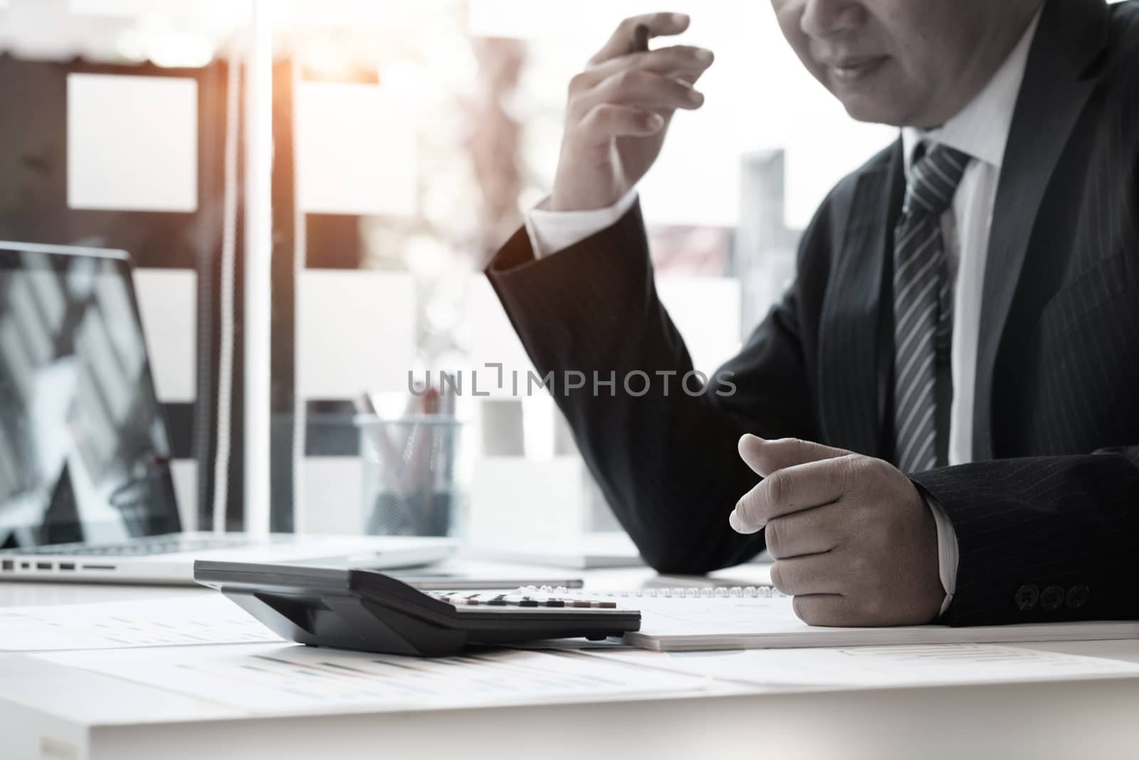 Businessman and calculator,Accounting conceptt vintage tone. by prathanchorruangsak