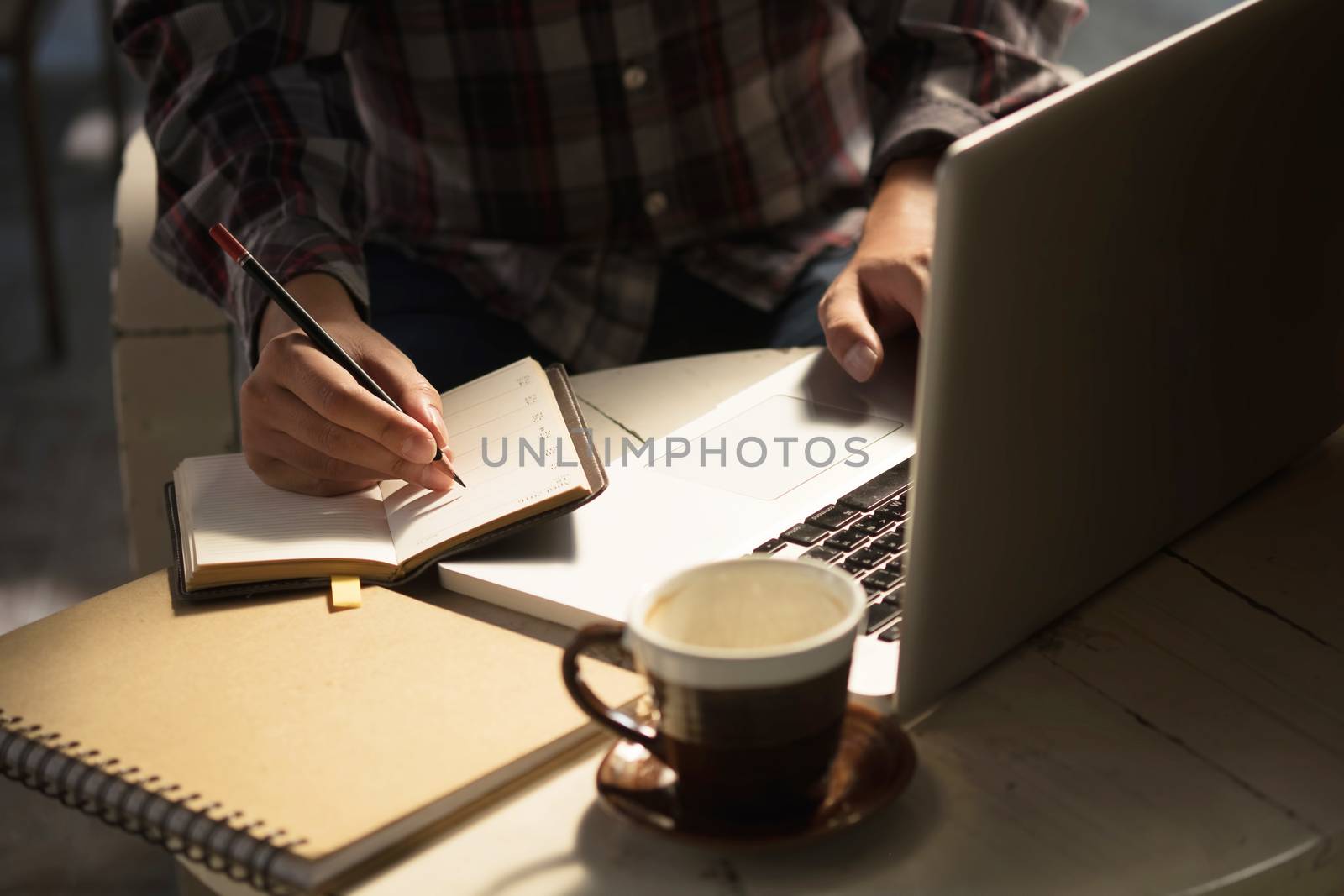 Closeup Novelist shot memo writing on paper notebook with vintag by prathanchorruangsak