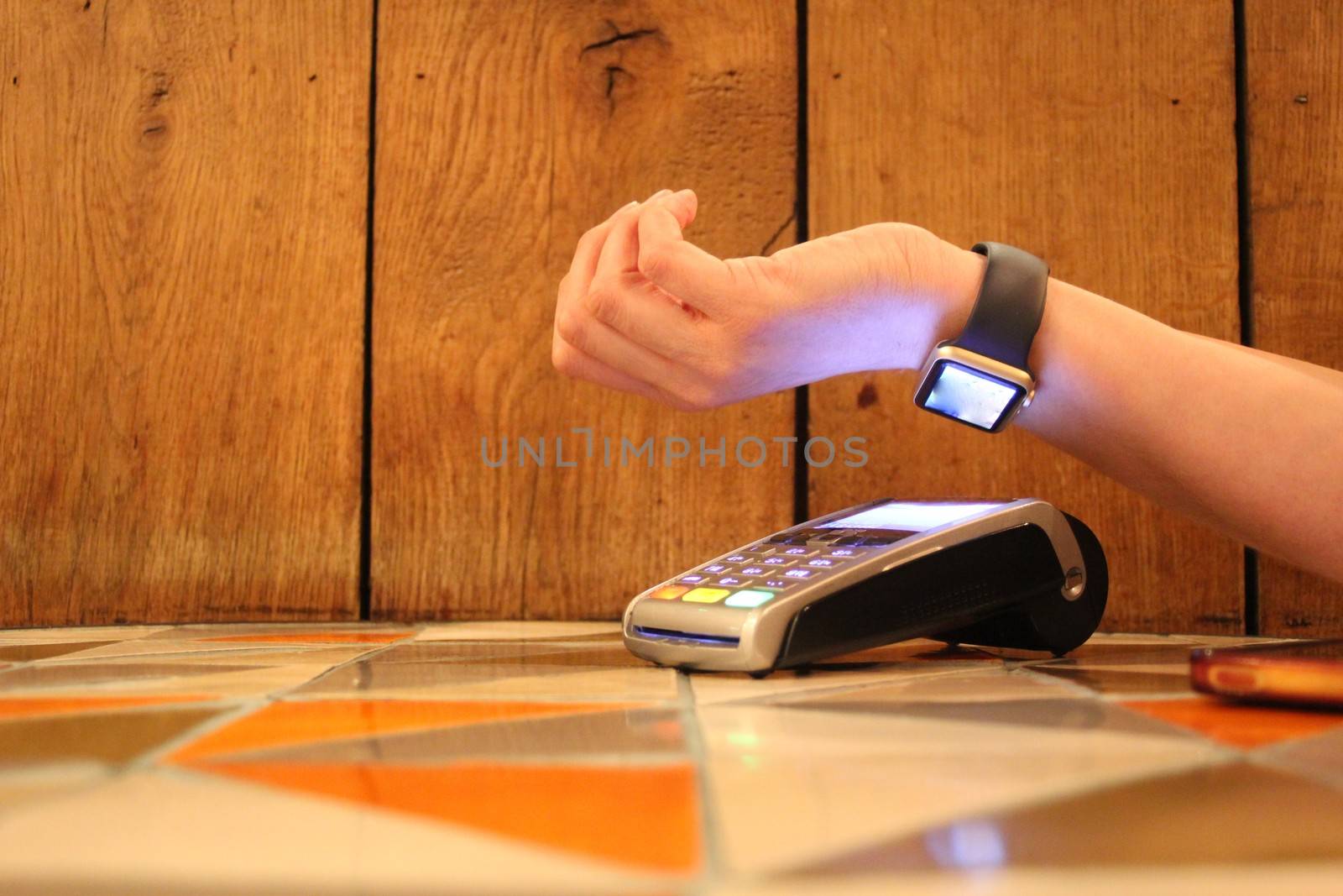 contactless payment watch smart pdq with hand holding credit card ready to pay