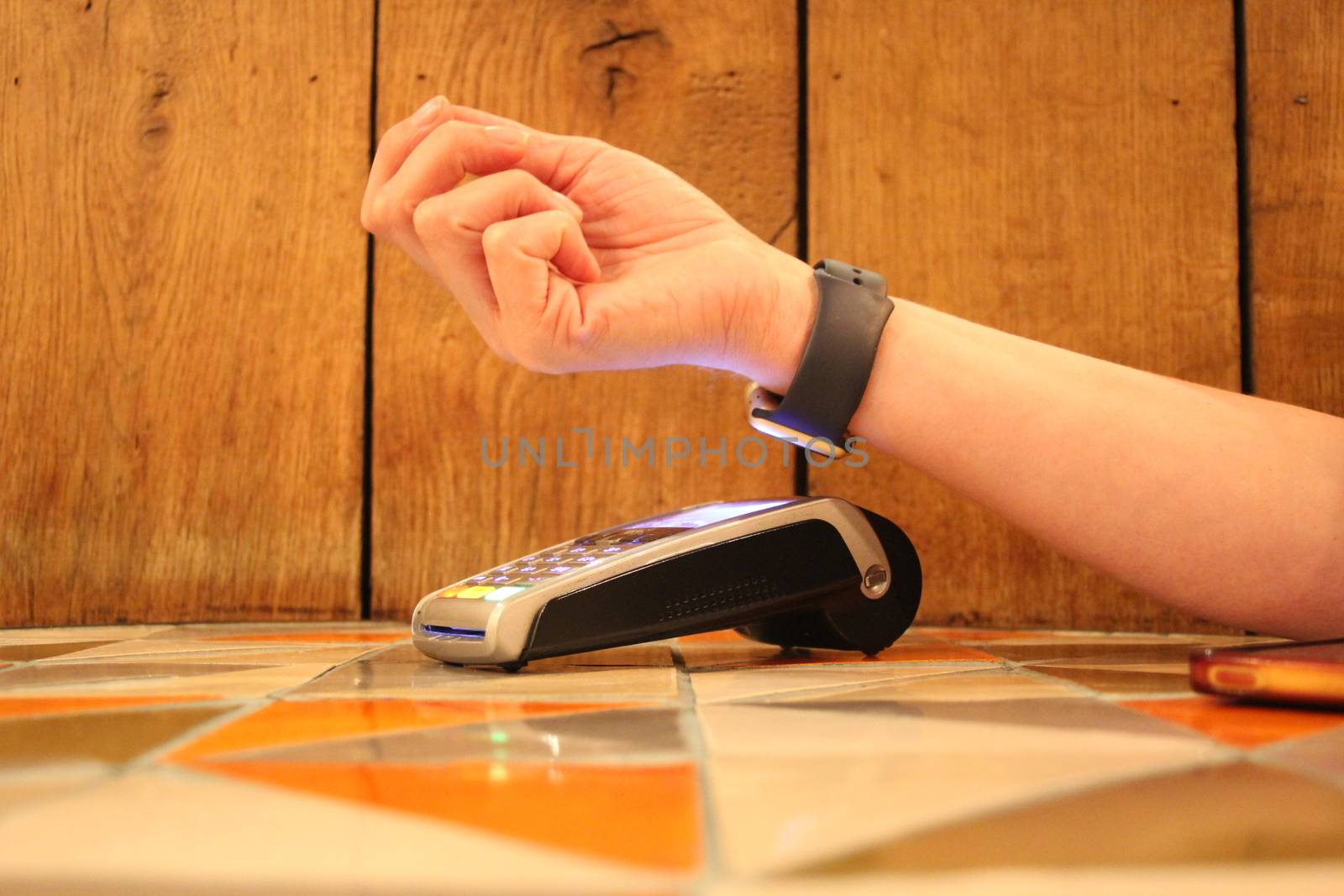 contactless payment smartwatch pdq with hand holding credit card to pay by cheekylorns