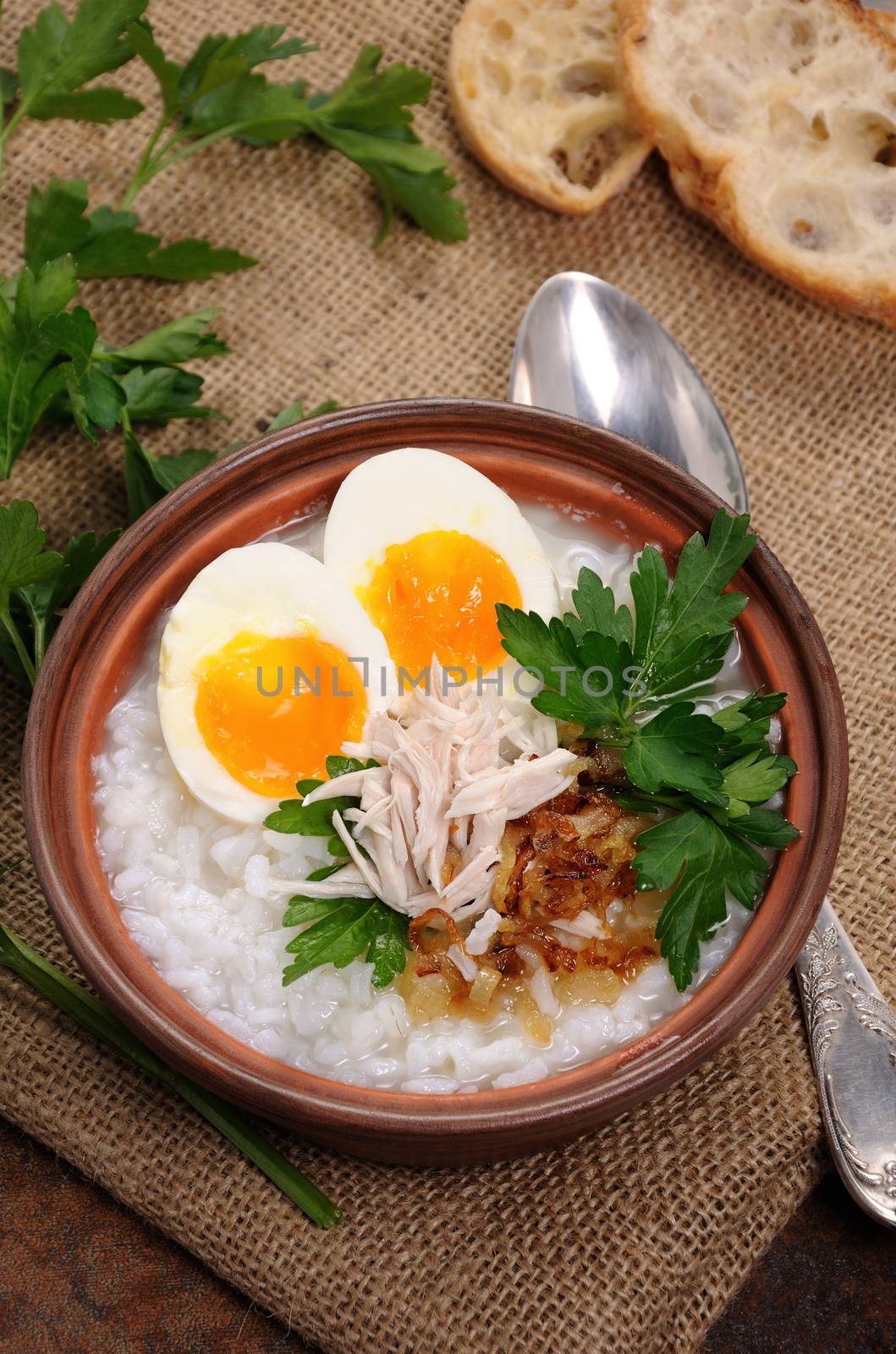 Rice porridge ginger congee with egg, chicken, crispy shallots and parsley