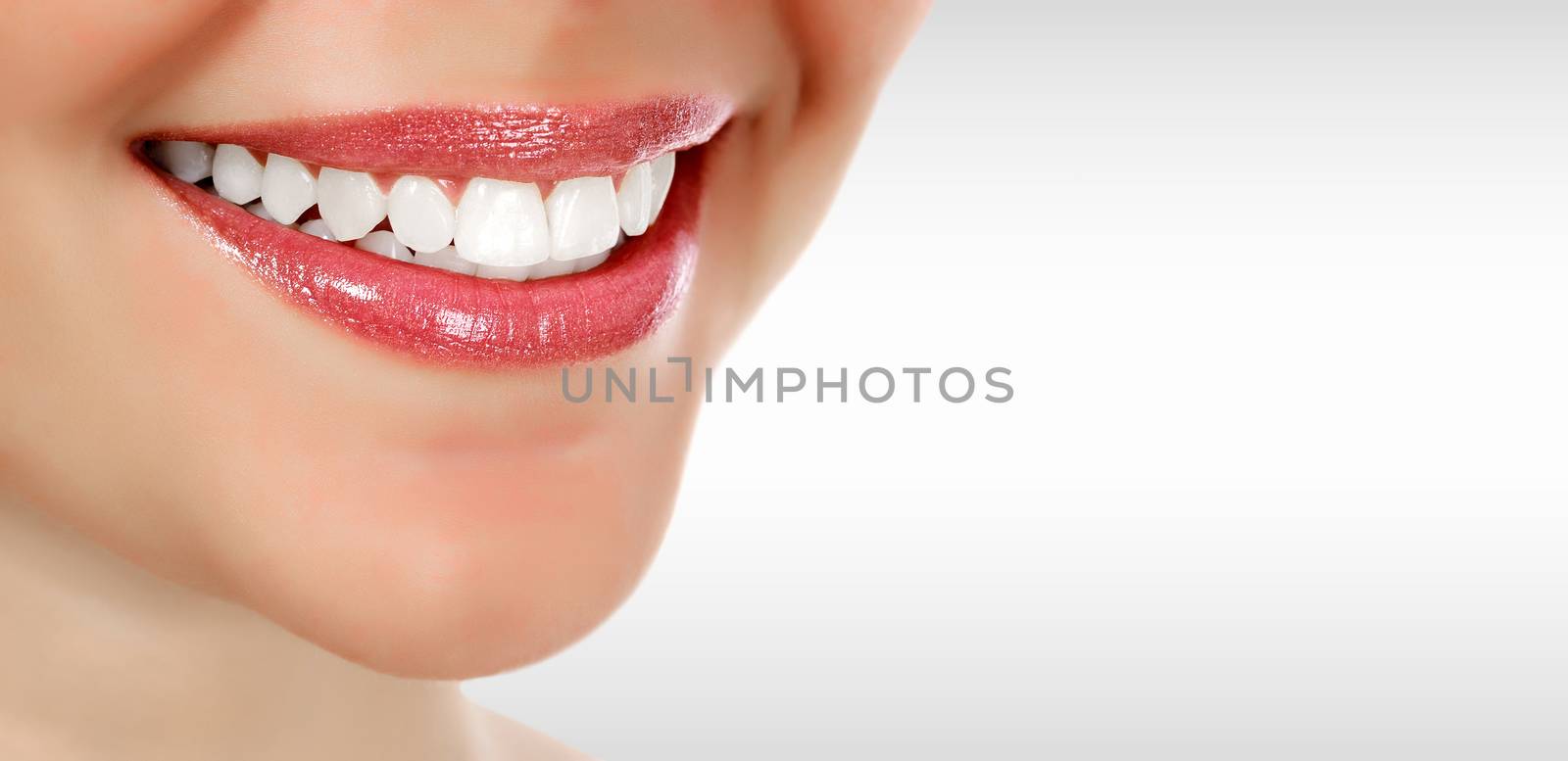 Pretty woman smiling against a grey background with copyspace. Closeup shot