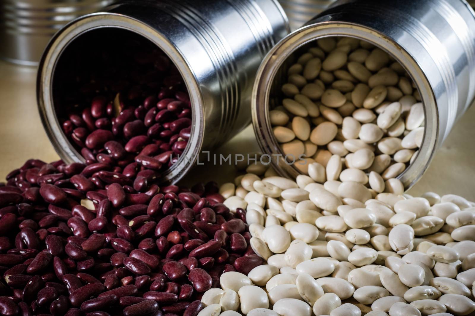 Delicious beans in a metal jar on a wooden kitchen table. Black background.