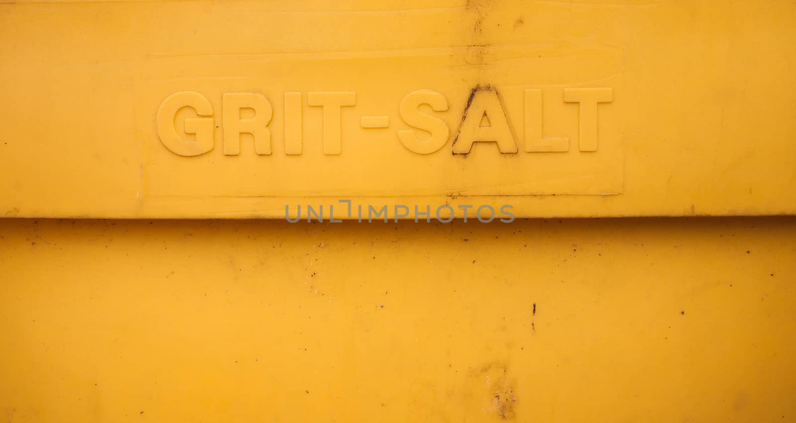 close up of yellow grit salt lettering on plastic container; UK