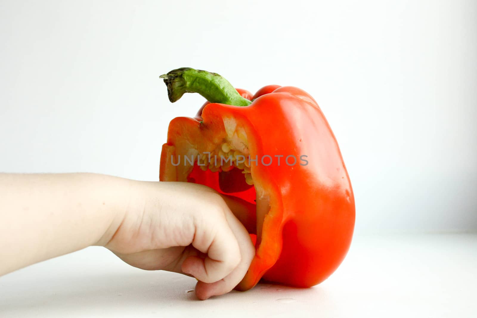 Pepper bulgarian red. A half is standing in front of a white background. The child to hold a rui in the inside. Photo for your design. Horizontal sheet orientation