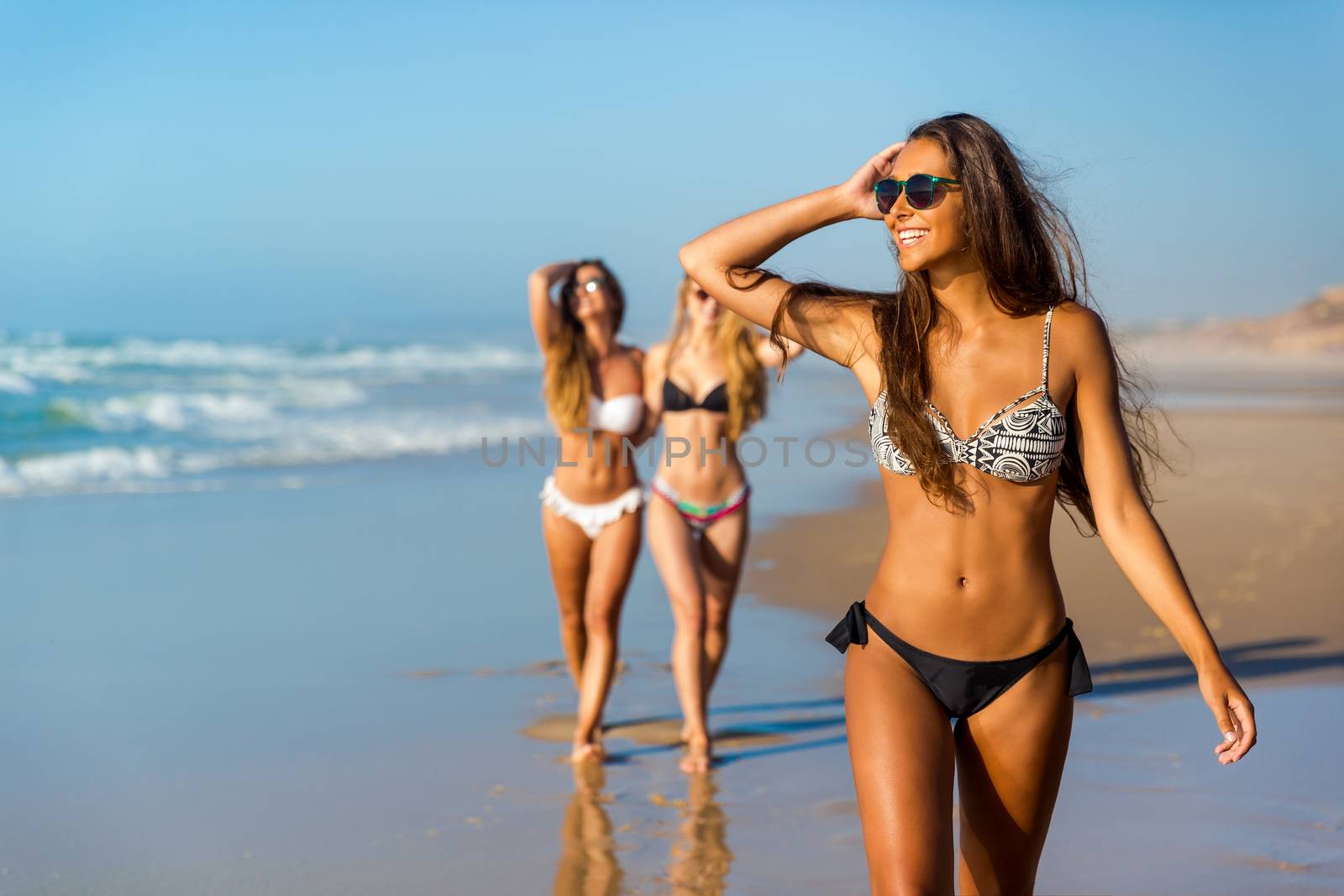 Three beautiful girls having fun on the beach