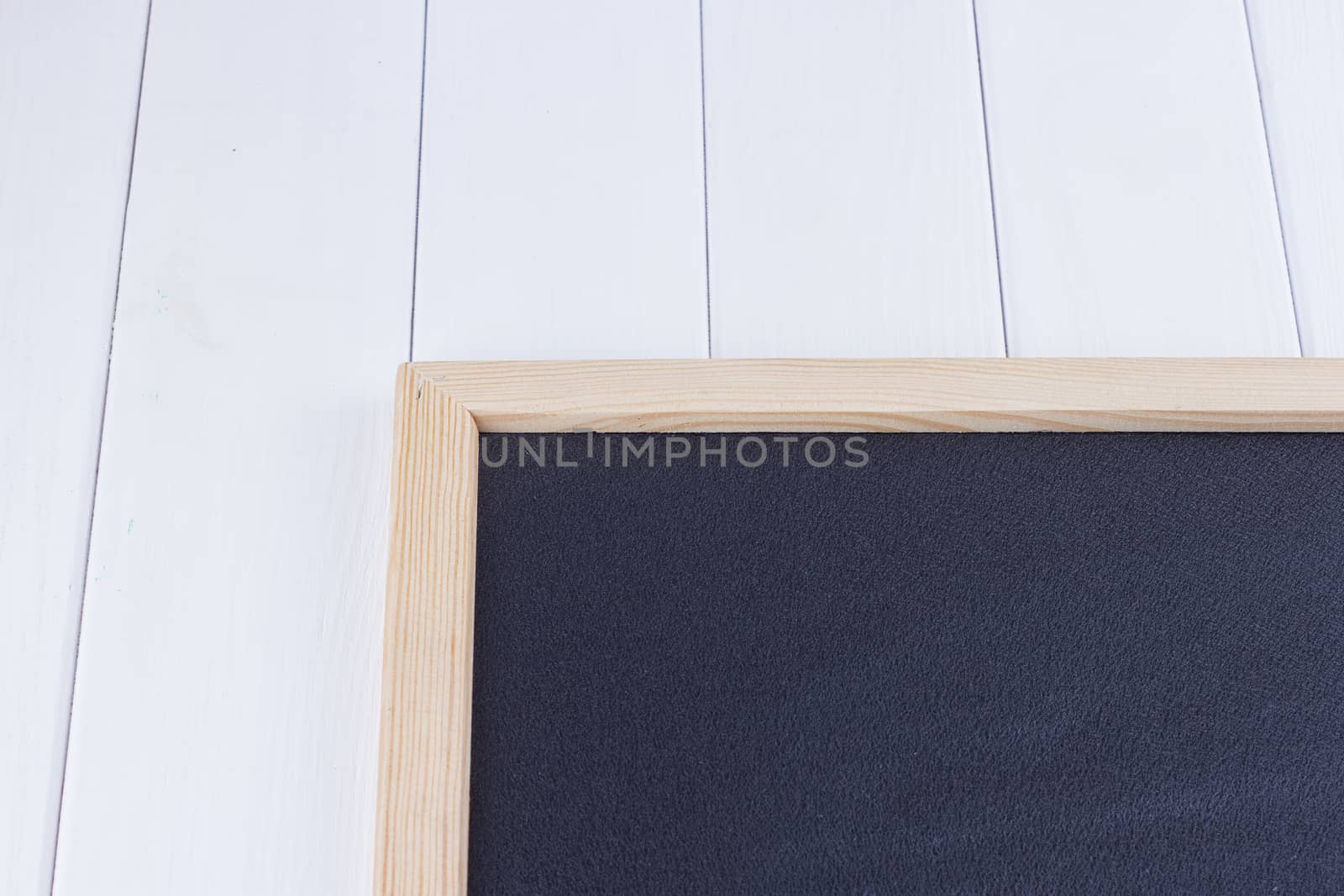 Old blank vintage school slate or chalkboard lying on an old rustic wooden background