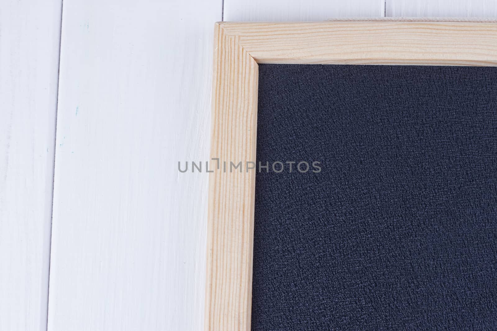 Old blank vintage school slate or chalkboard lying on an old rustic wooden background