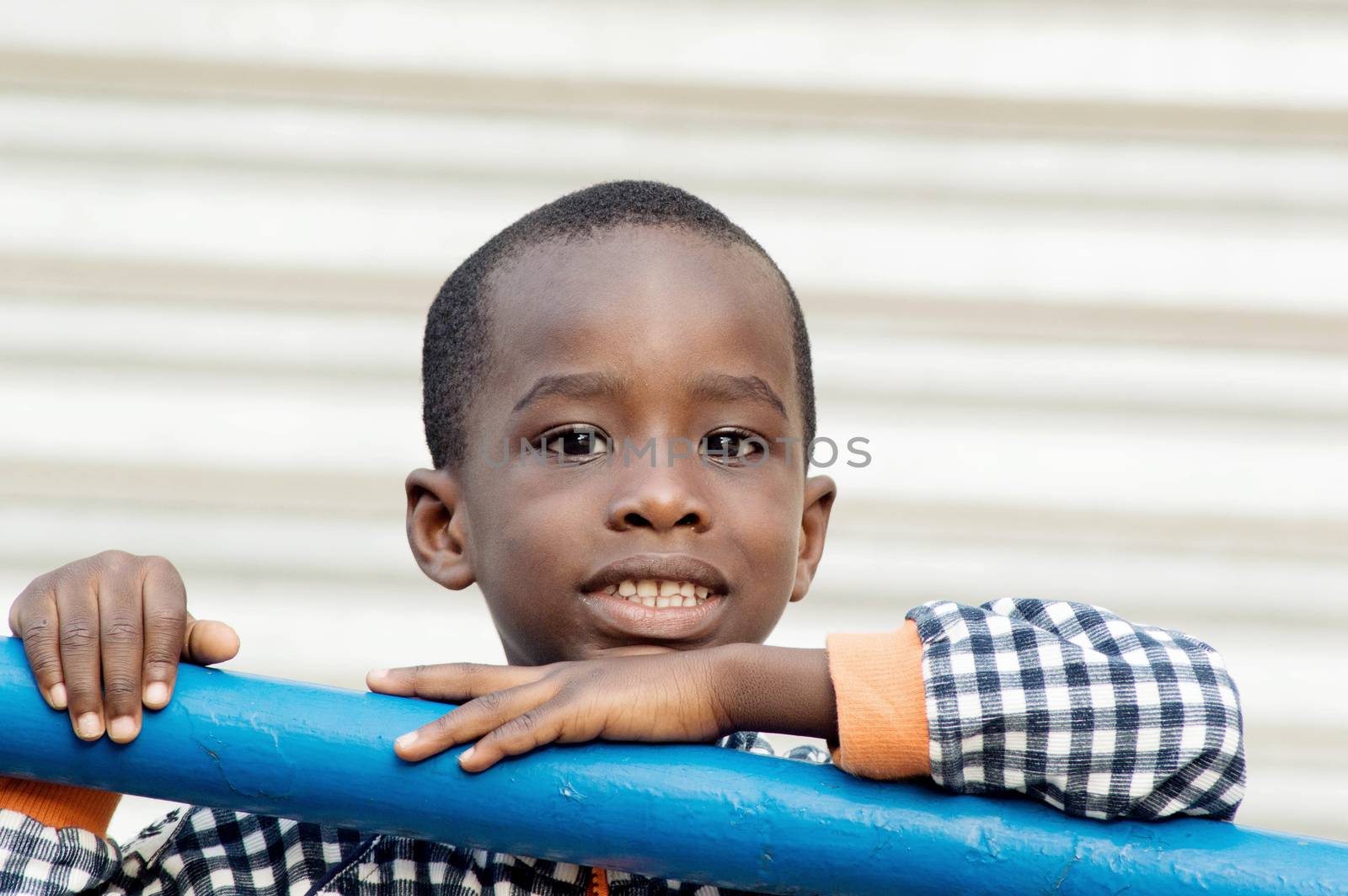 This smiling child is backed by an iron bar