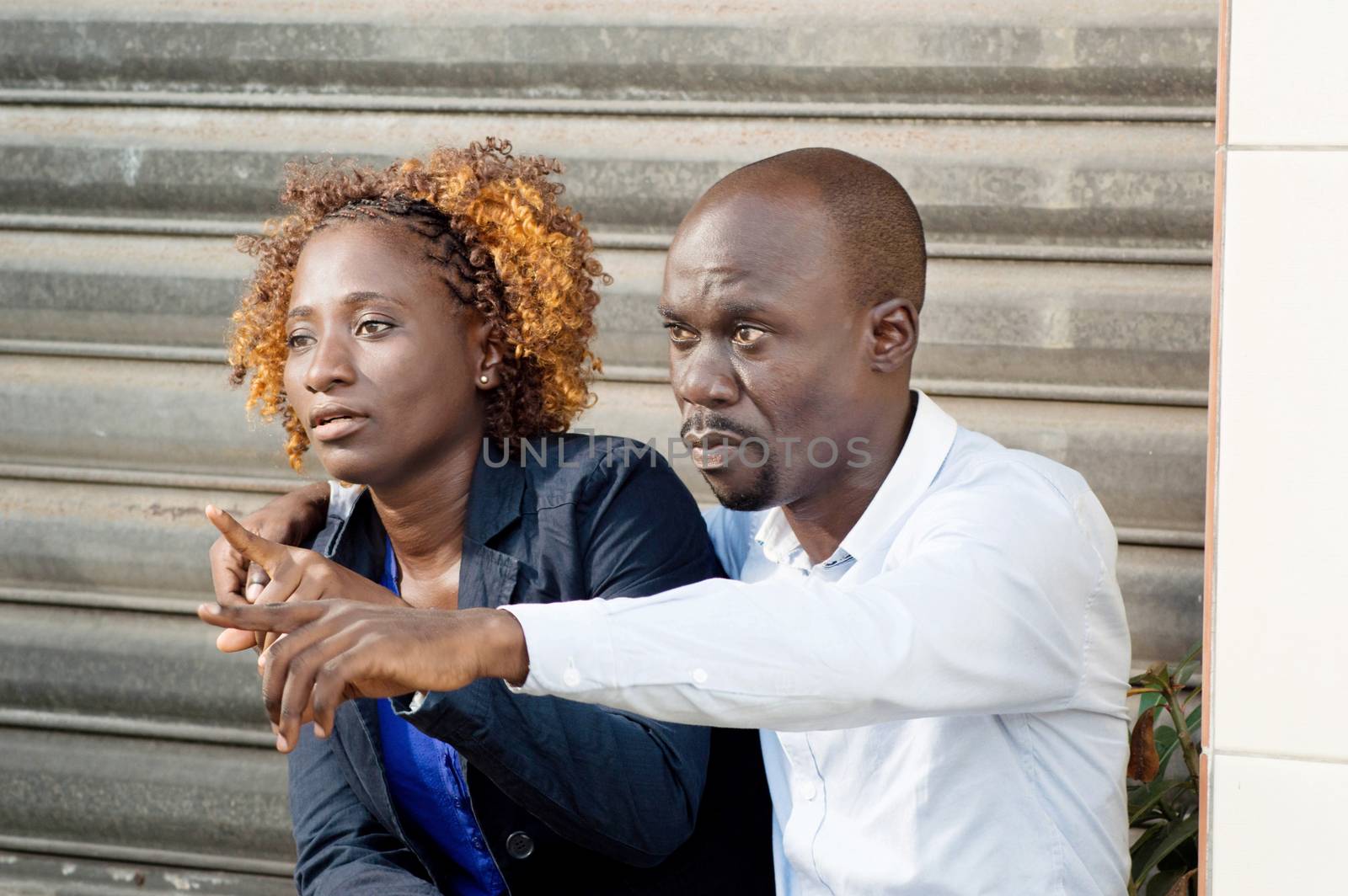 This couple exchange sitting outdoors.