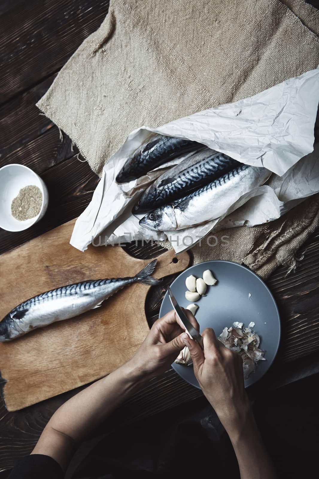 Woman preparing fish by Novic
