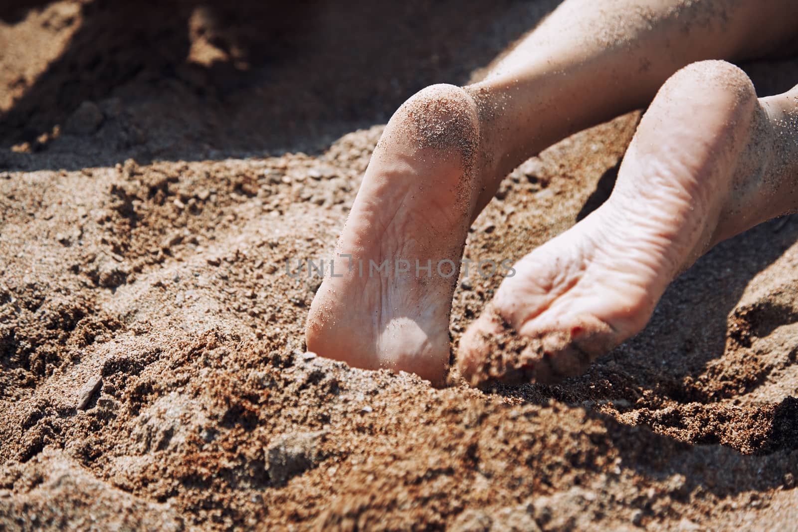 Legs of woman laying at the beach by Novic