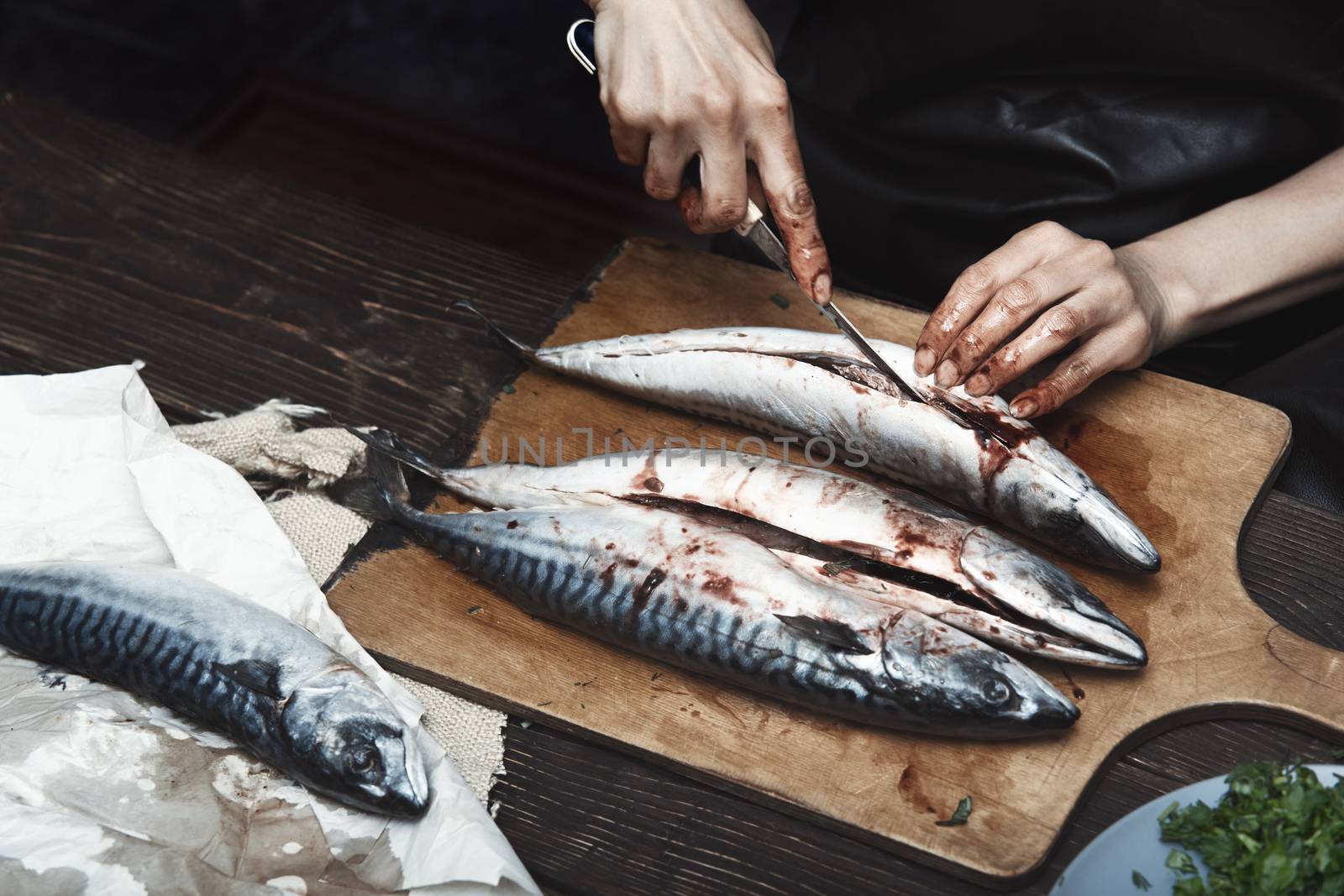 Woman preparing mackerel fish by Novic