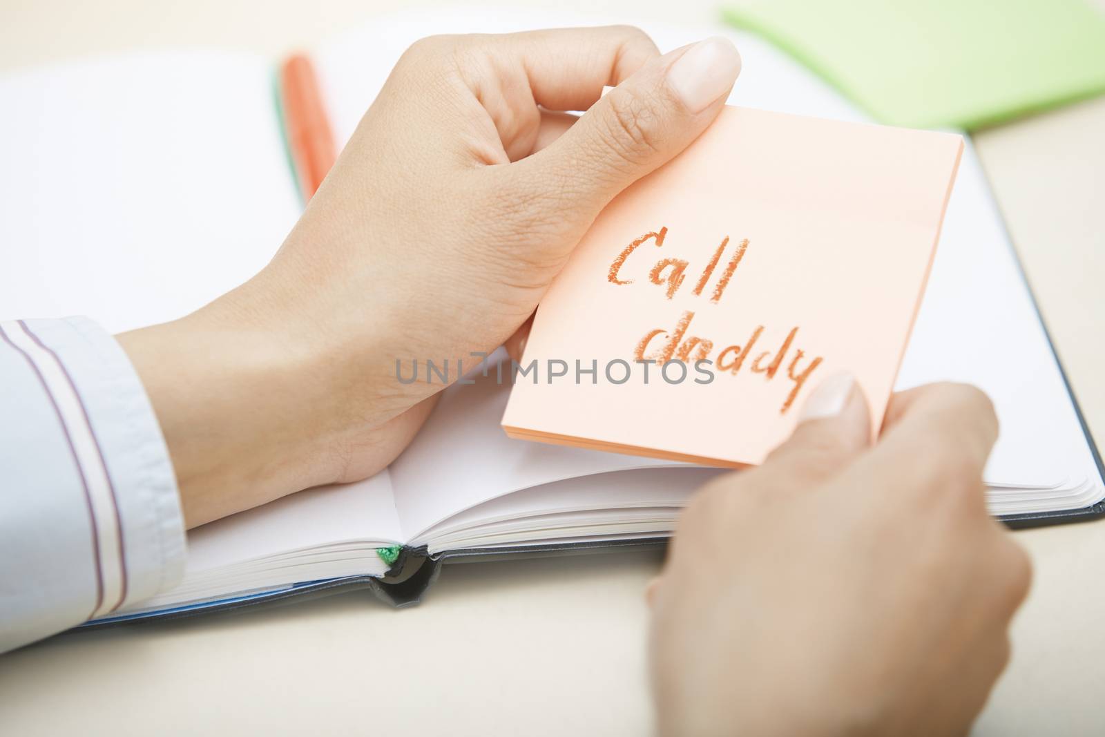 Hands holding sticky note with Call daddy text