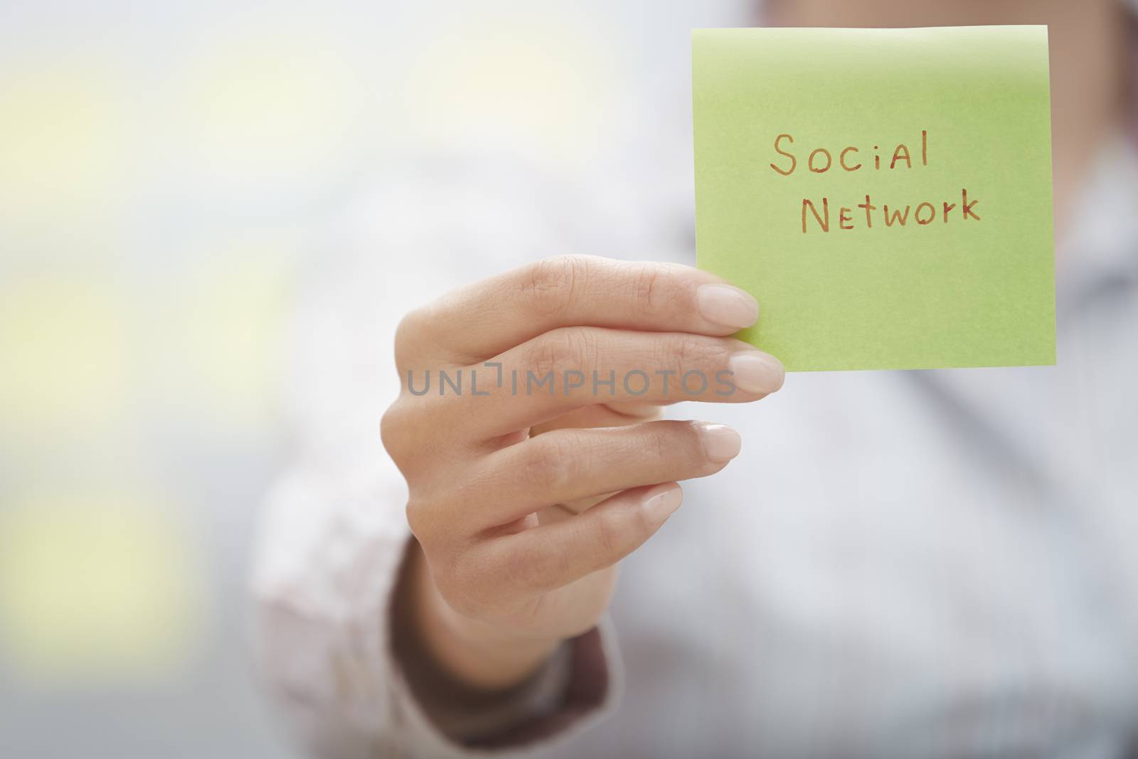 Woman holding sticky note with Social network text