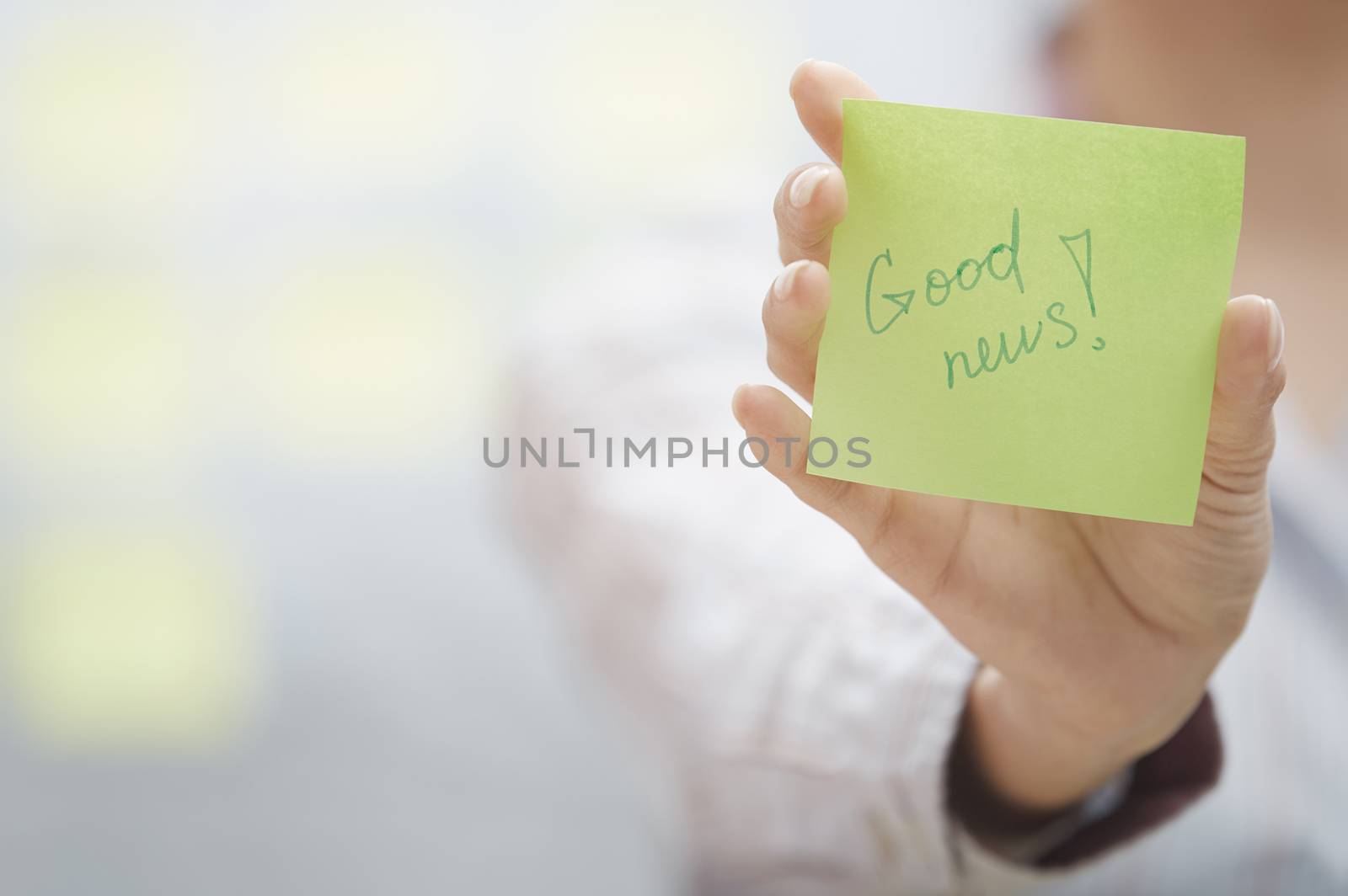 Woman holding sticky note with Good news text