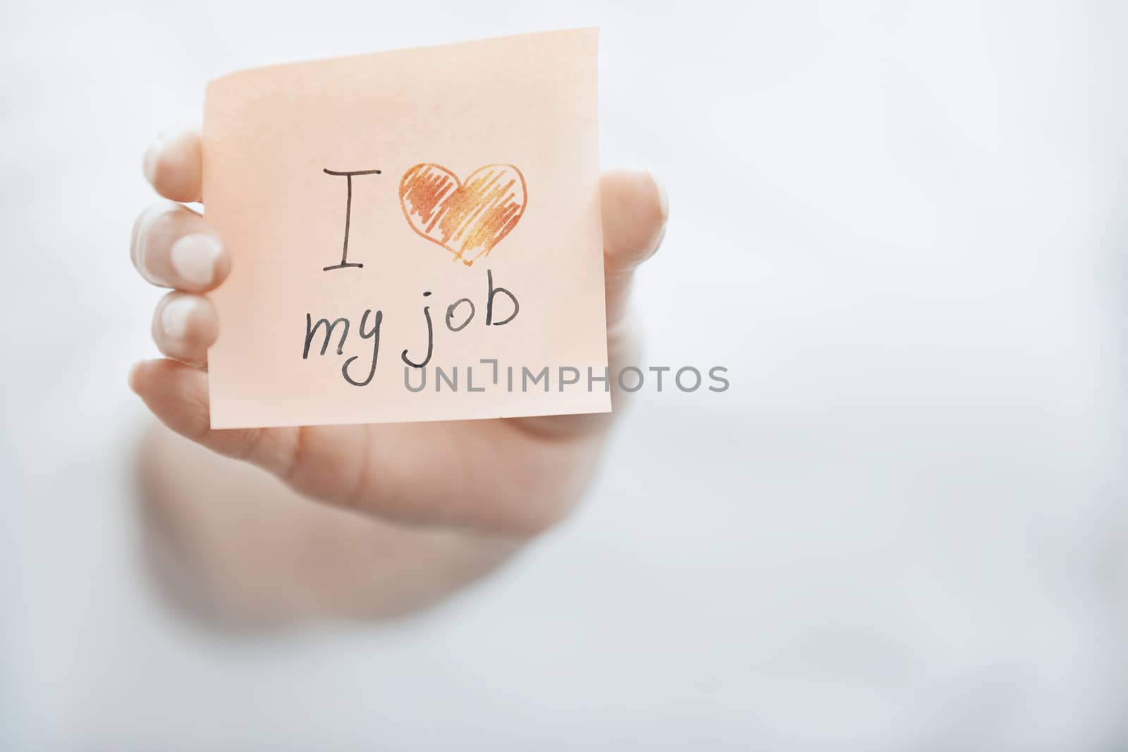 Hand of woman holding adhesive note with text