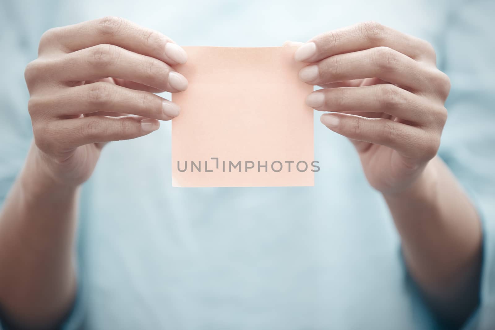 Woman holding adhesive note