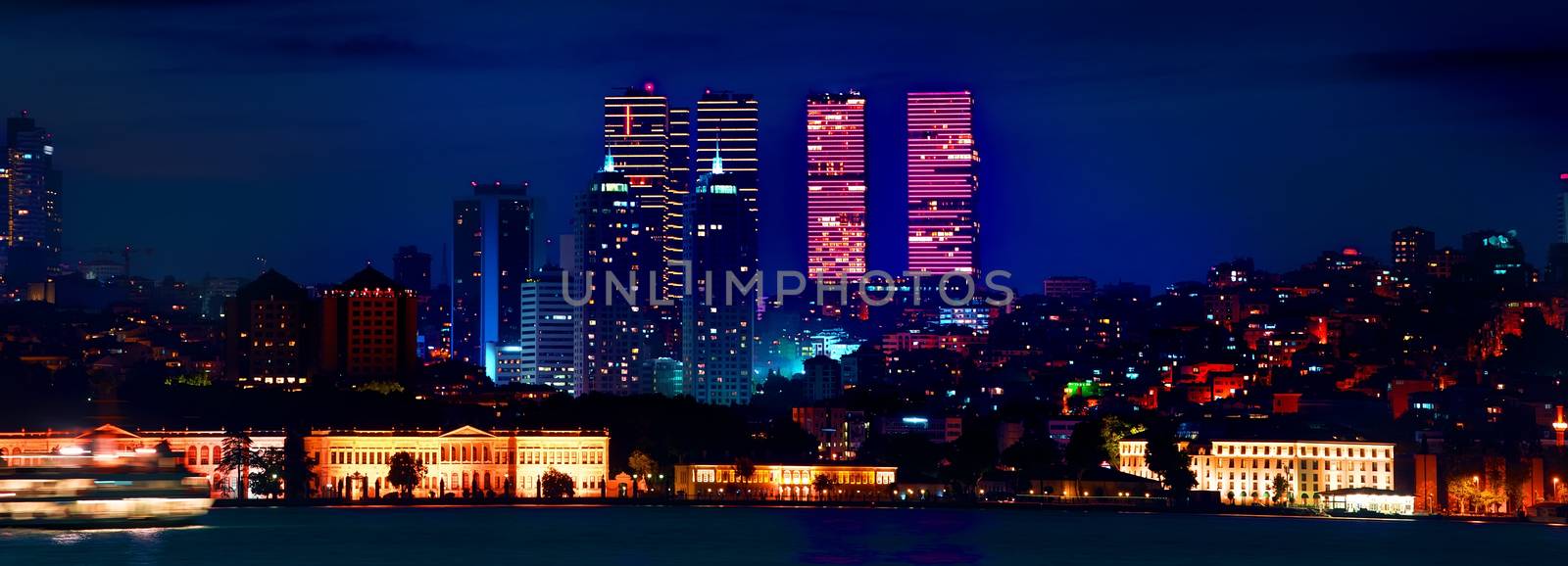 View on skyscrapers and Dolmabahce palace in european district of Istanbul at night, Turkey