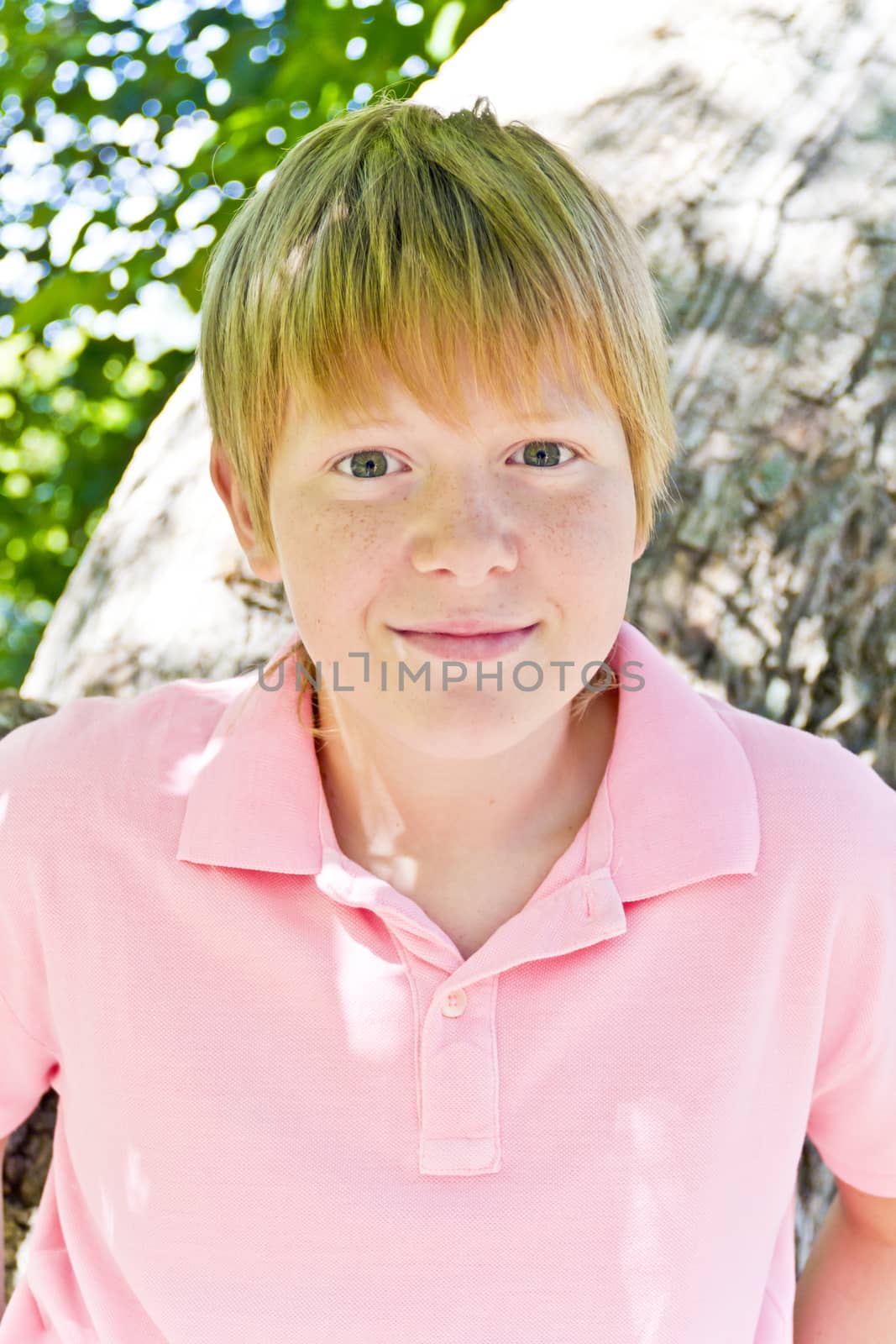 Portrait of cute blond boy in a pink shirt