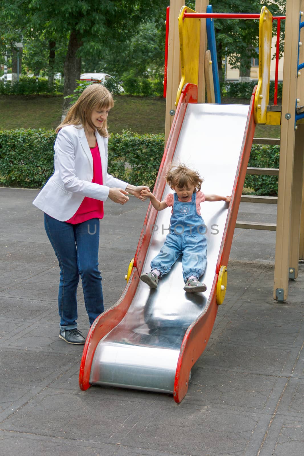 Mother with baby girl riding on hutches with screw up one eyes