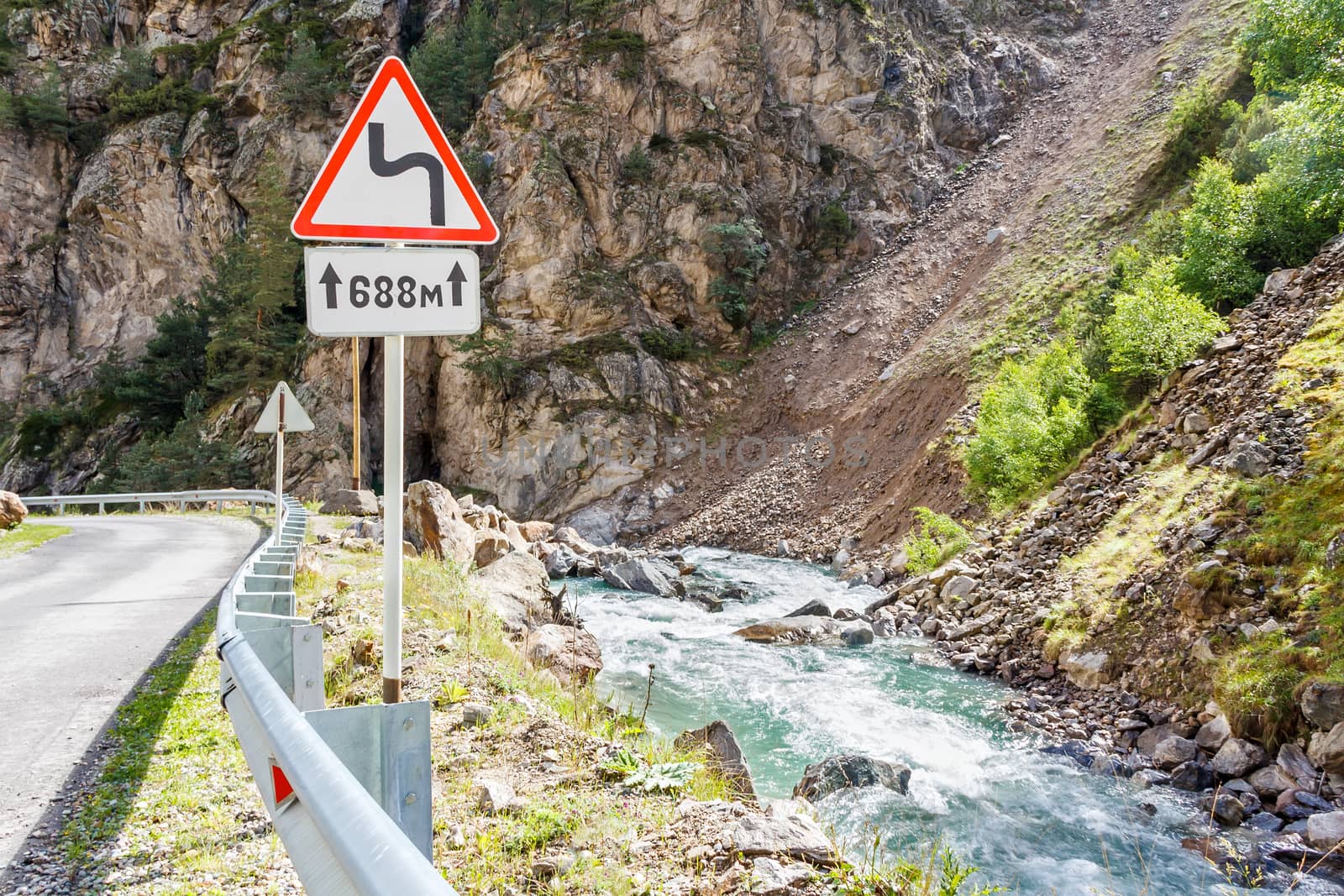 Landscape with mountains road and sign near river