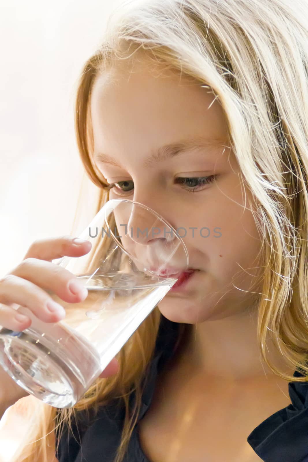 Cute girl with blond hair are drinking water