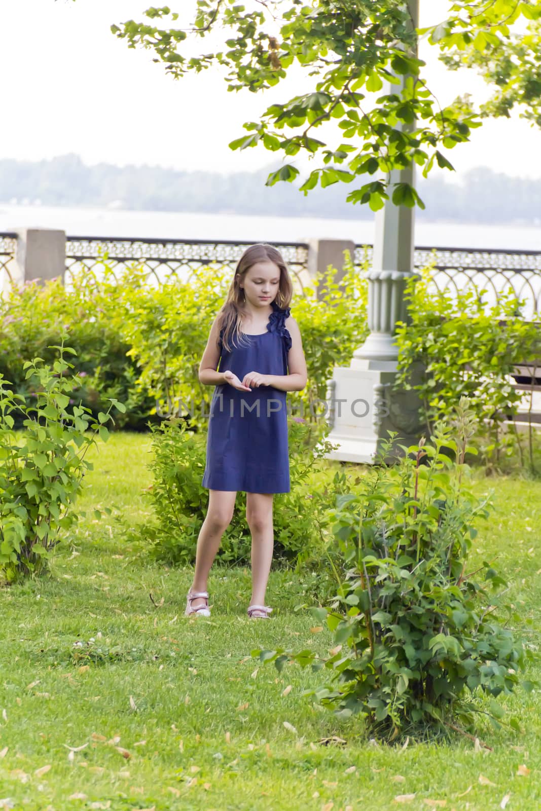 Cute blond girl with disheveled hair in green park