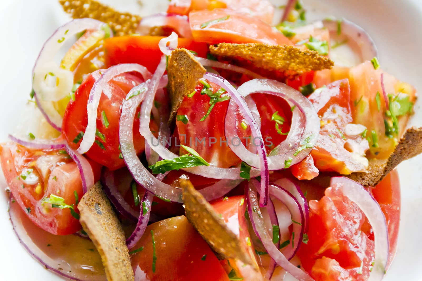 Colorful salad with red tomato onions and bread