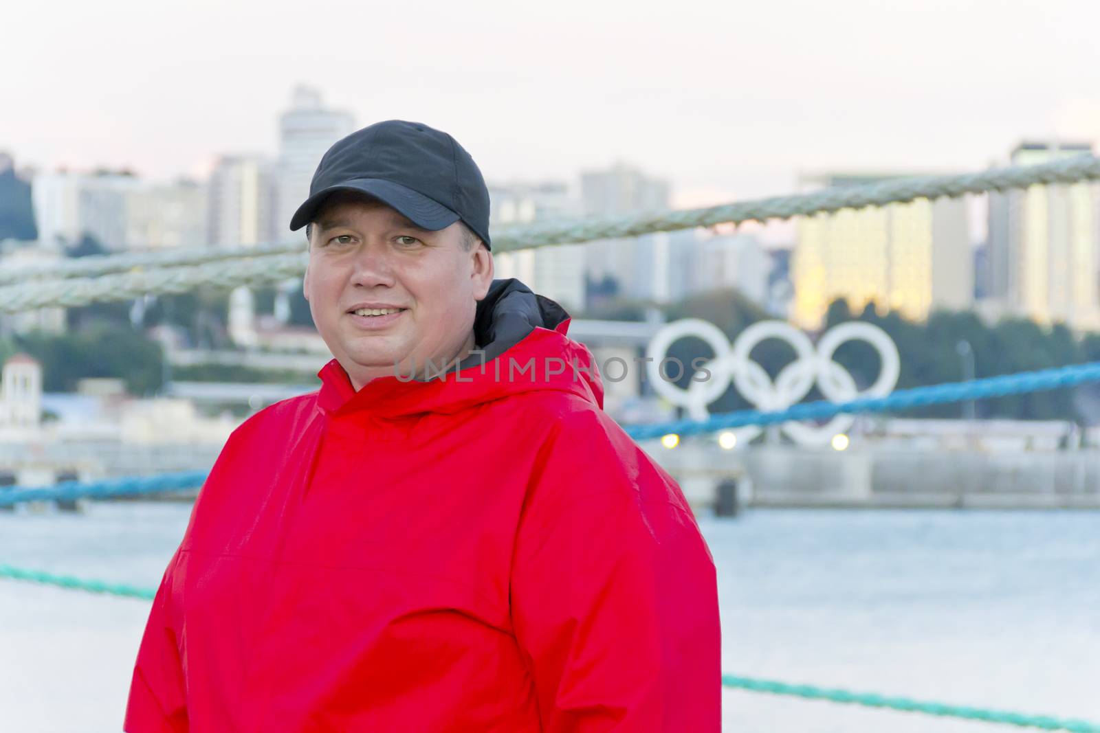 Big fat man in red jacket on embankment by Julialine