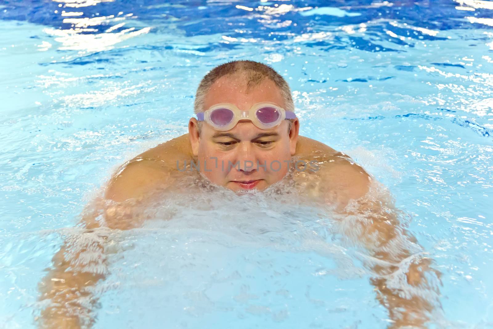 Big fat man in the swimming pool playing sports