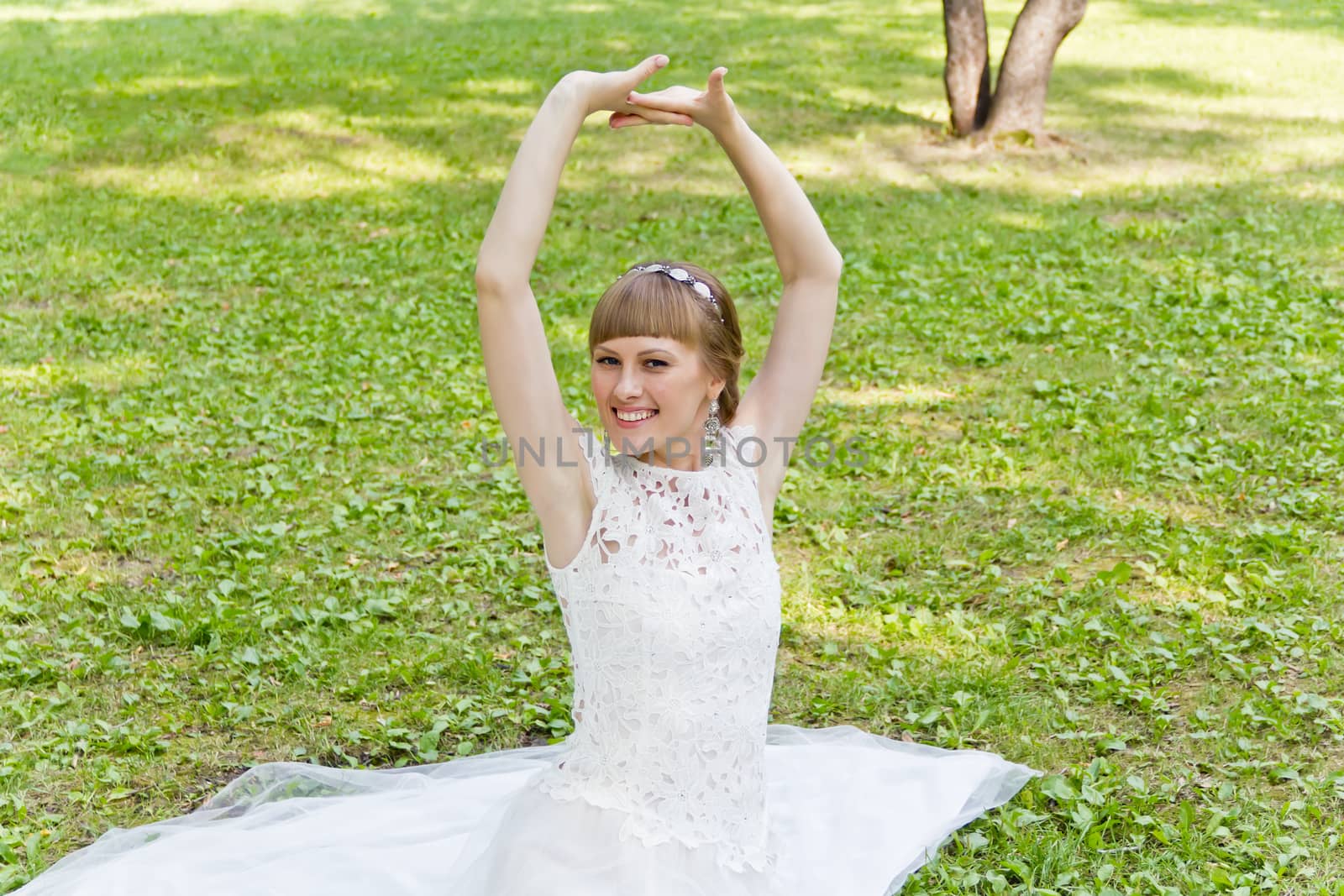 Beautiful bride in white lace dress with upwards hands