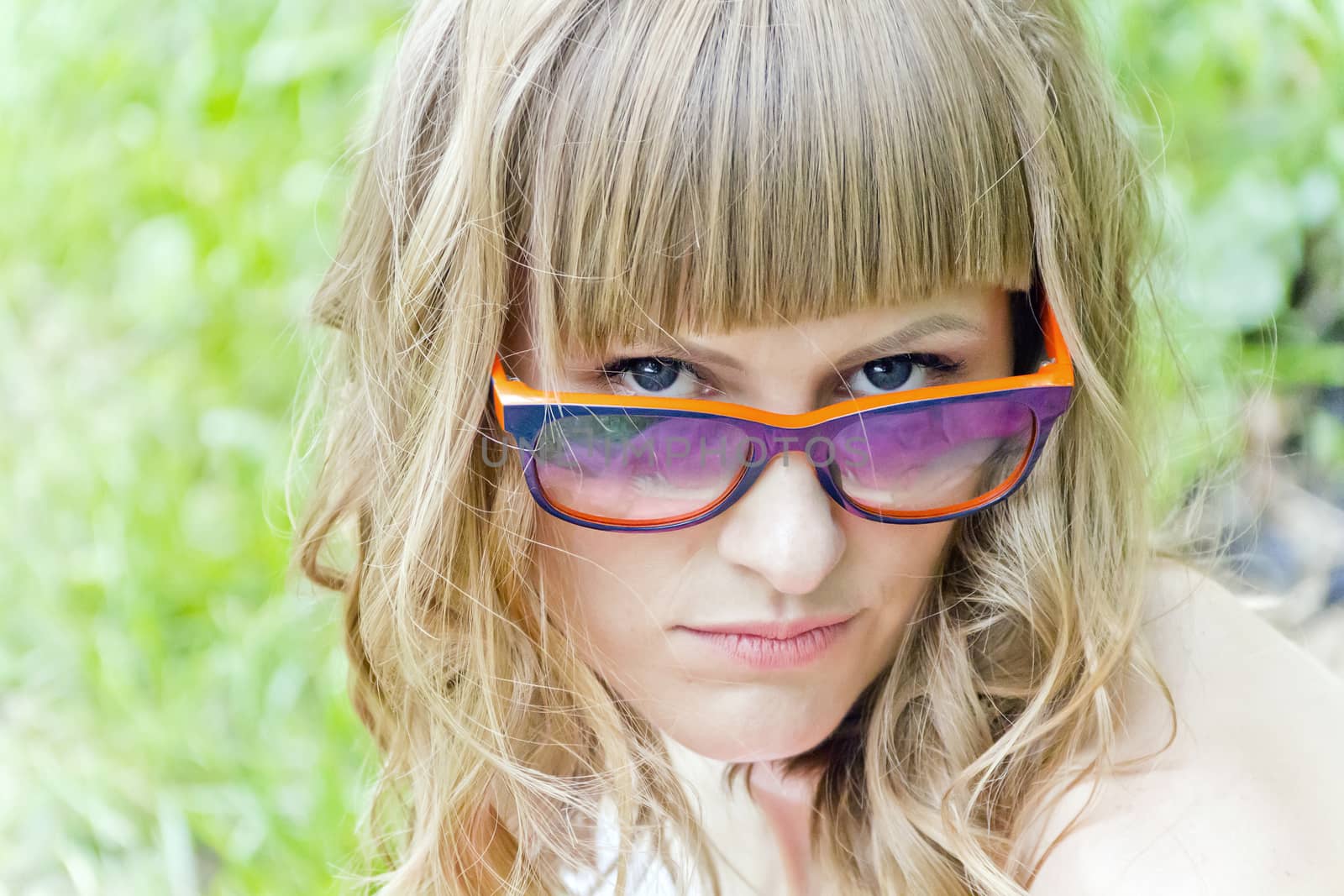 Portrait of beautiful girl with with sunglasses on green background