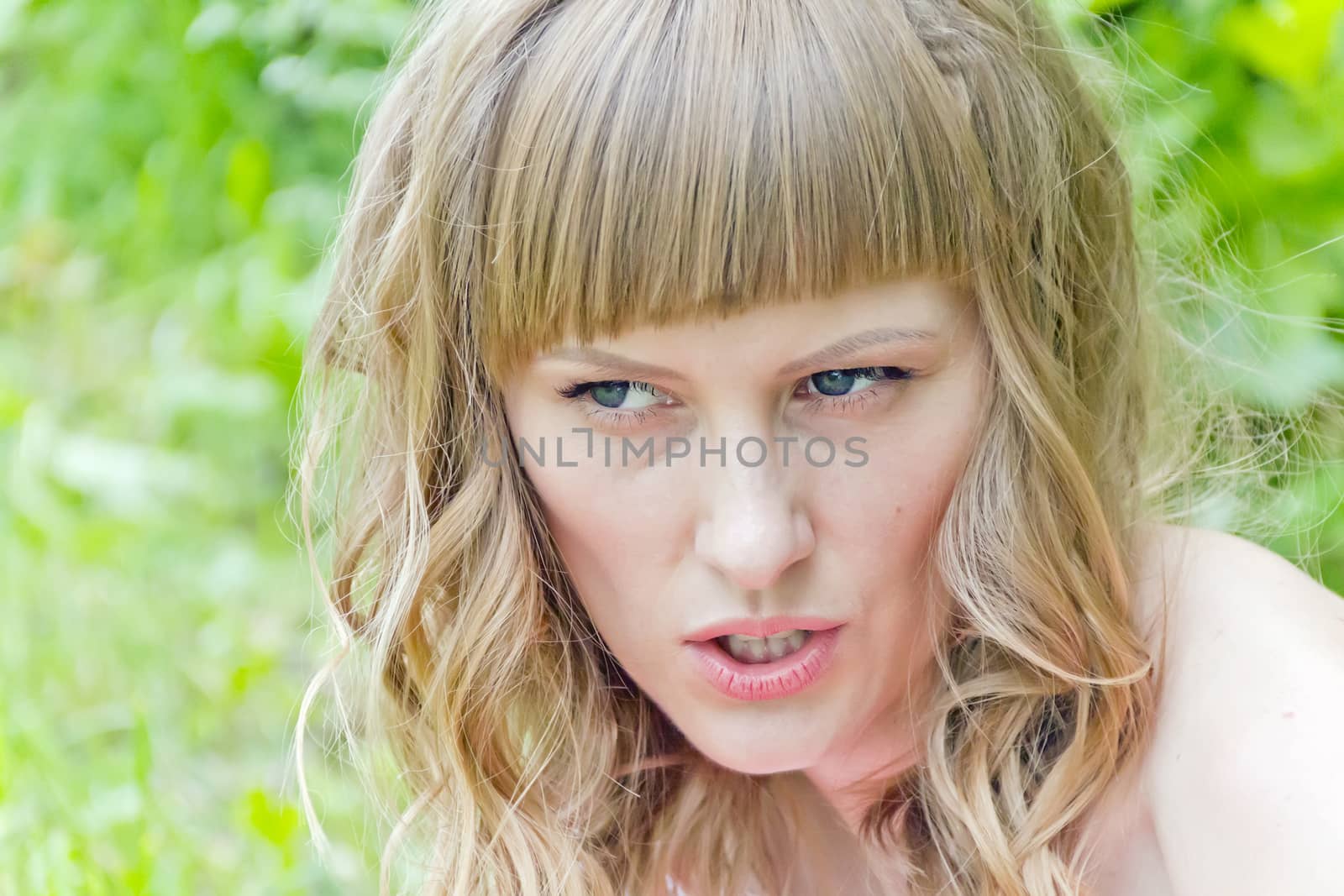 Portrait of beautiful girl with blue eyes on green background