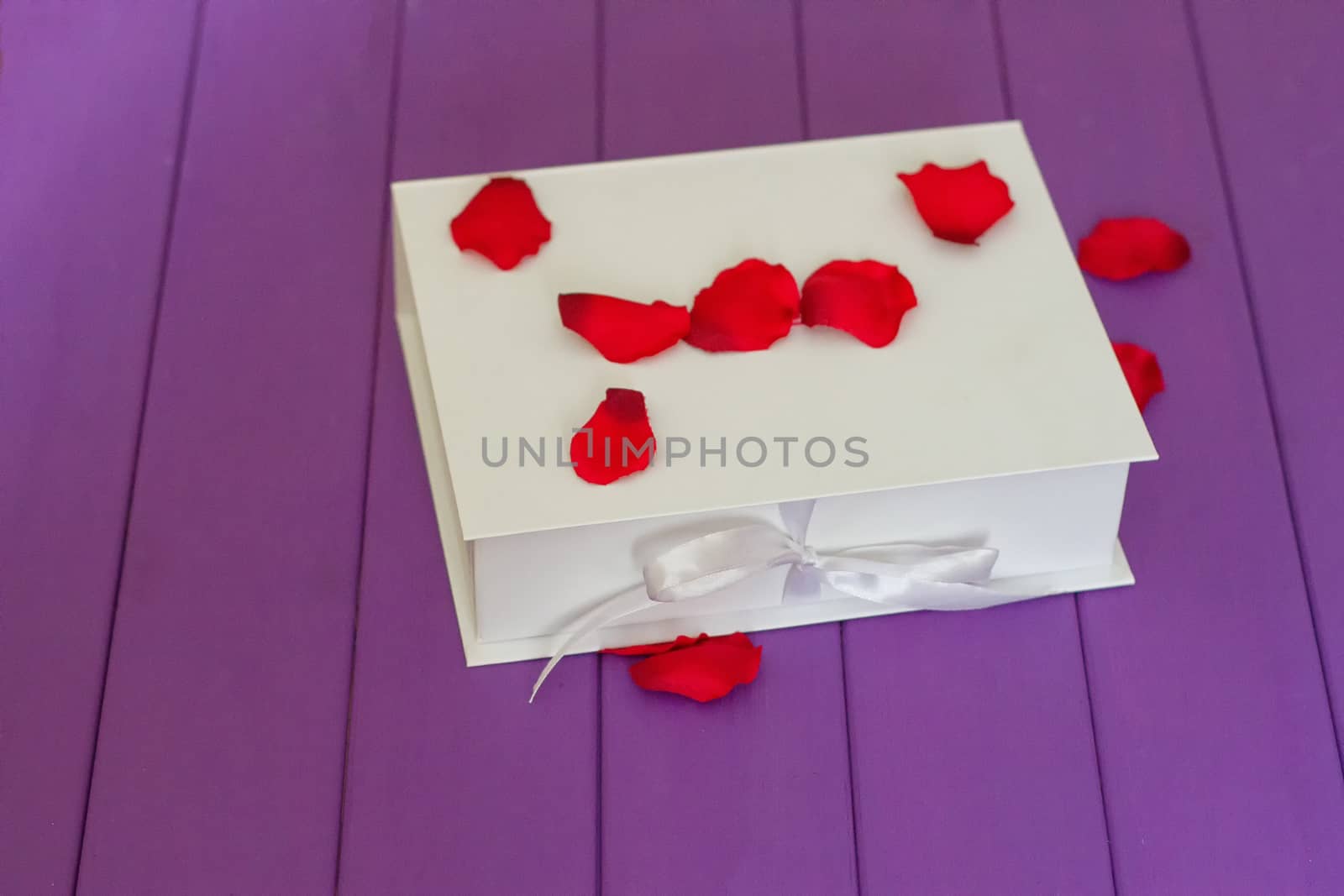 Rose petals and gift box with ribbon