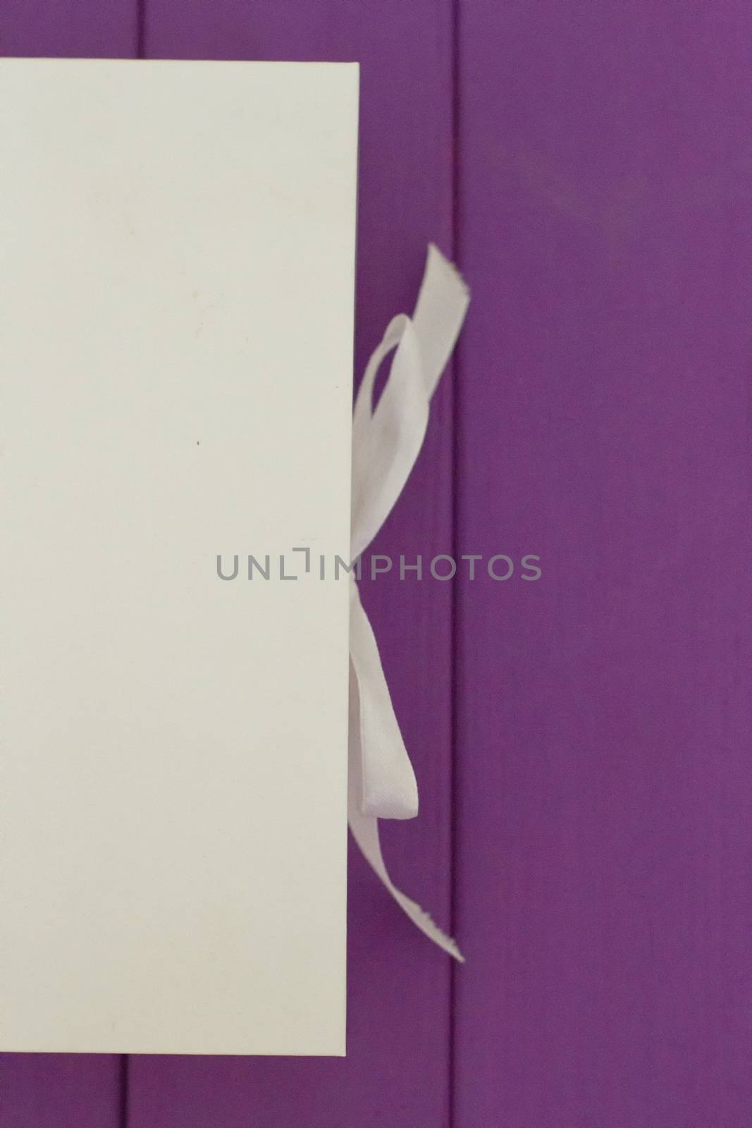 White box on the tie on a purple wooden background. Mocap