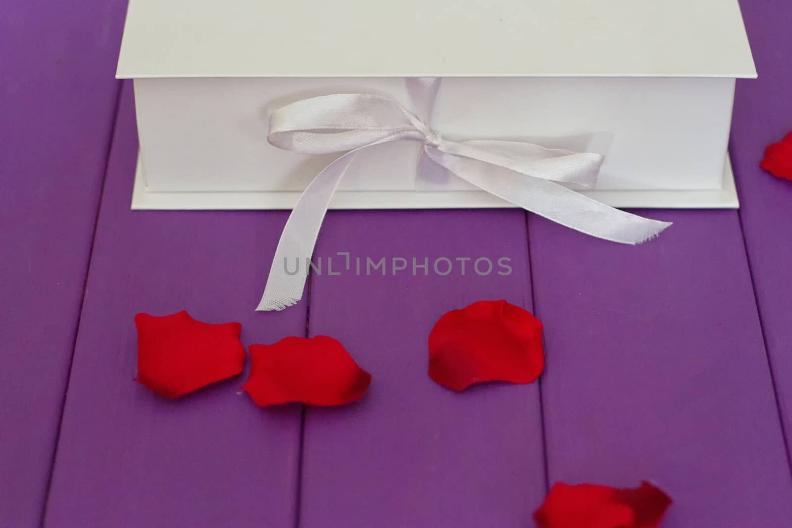 Rose petals and gift box with ribbon