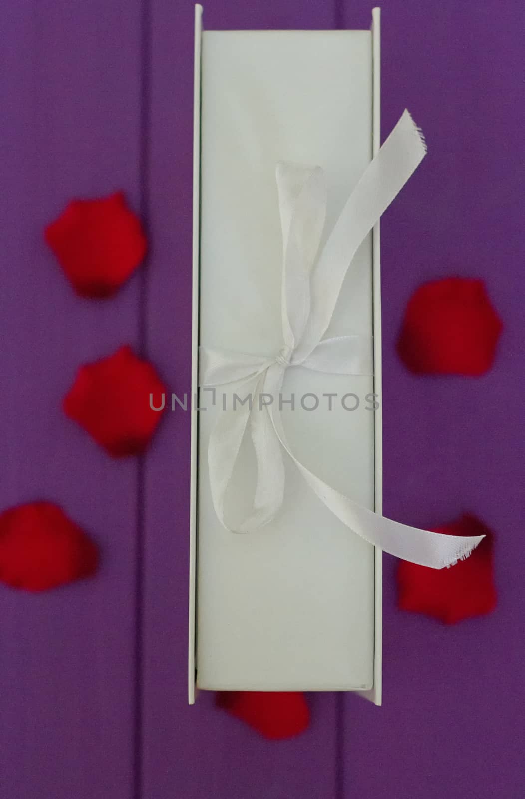 Rose petals and gift box with ribbon