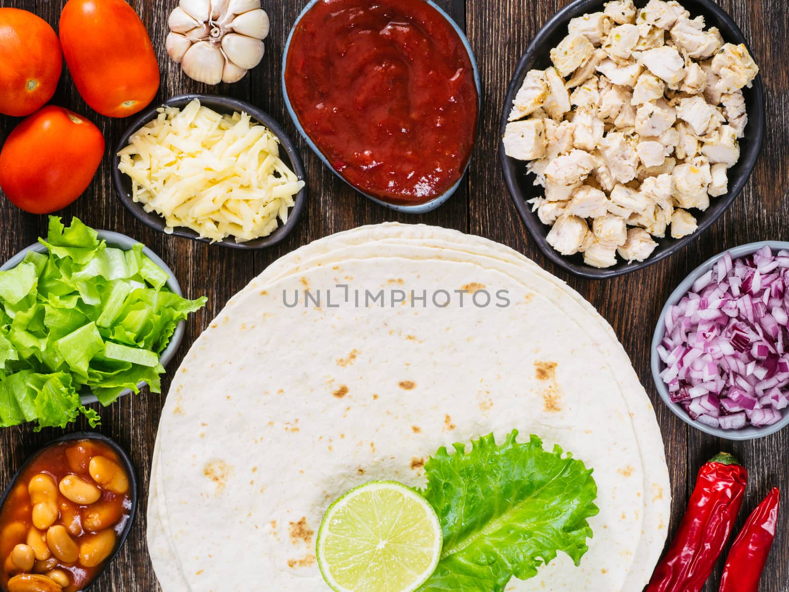 Traditional mexican tortilla with mix of ingredients on brown wooden background