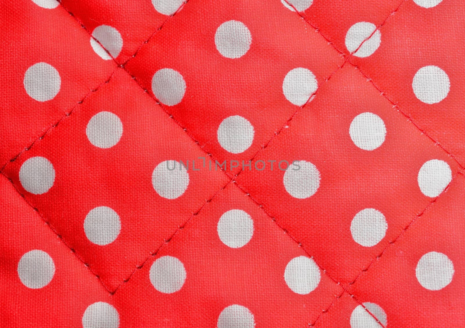 Background shot of a red polka dot canvas with seams.