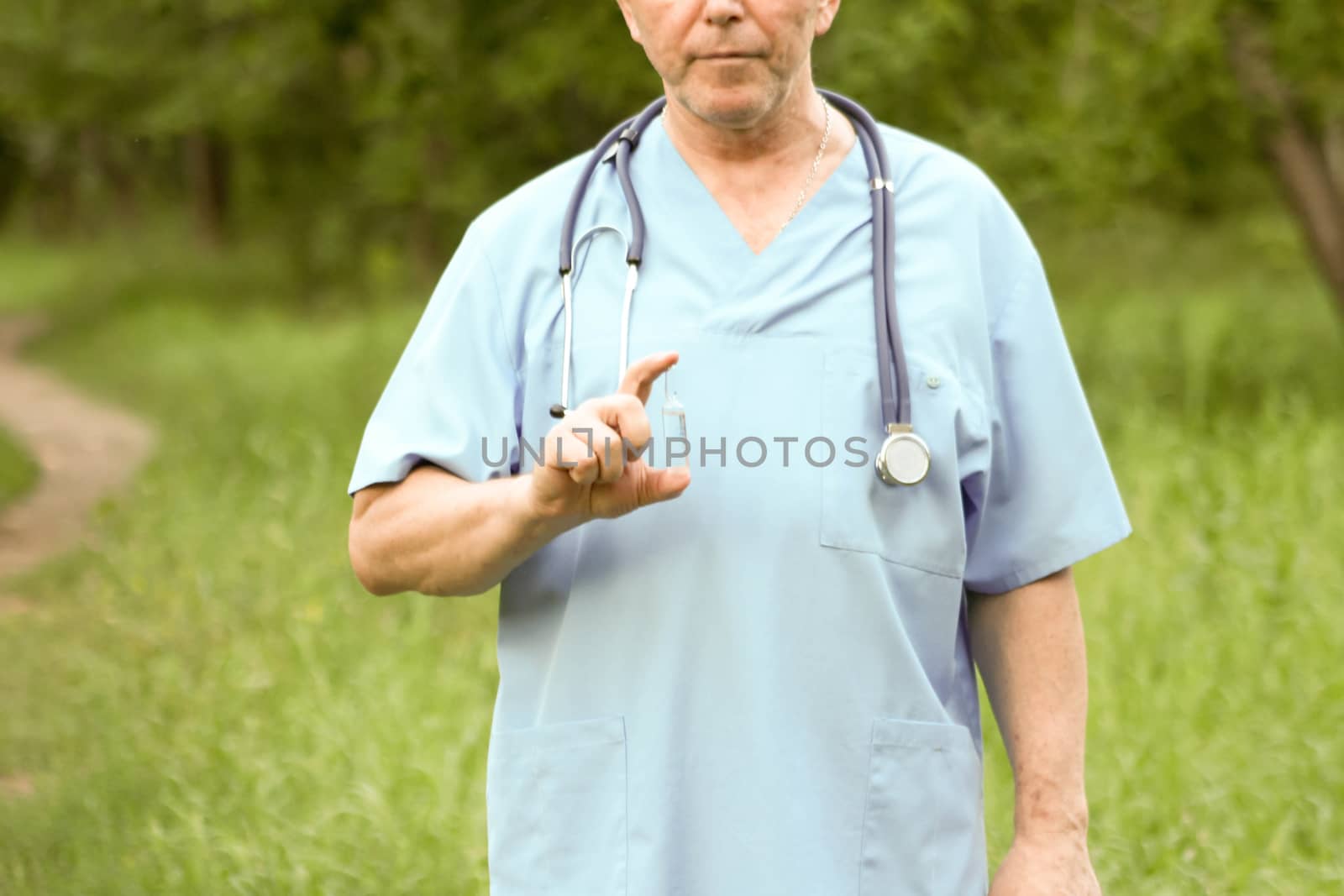 Doctor concept. The doctor in the medical dressing gown holds a whisker finger. Photo horizontal for your design. Against the background of nature.