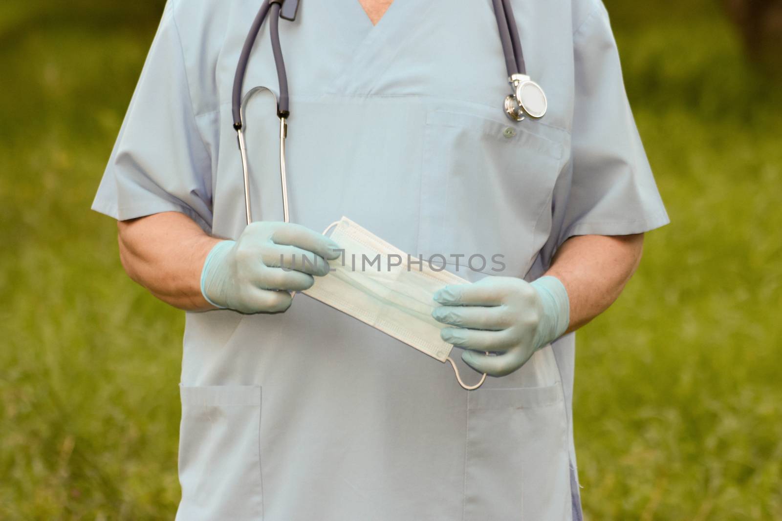 Doctor concept treatment nature. The doctor is holding a medical mask in his hands. Photo horizontal for your design.
