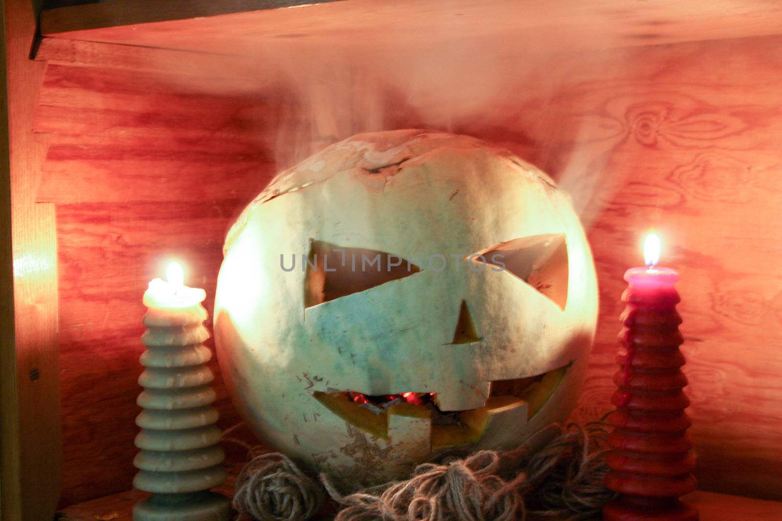 Halloween concept. The pumpkin smiling is burning in the fire. White smoke. Photo for your design