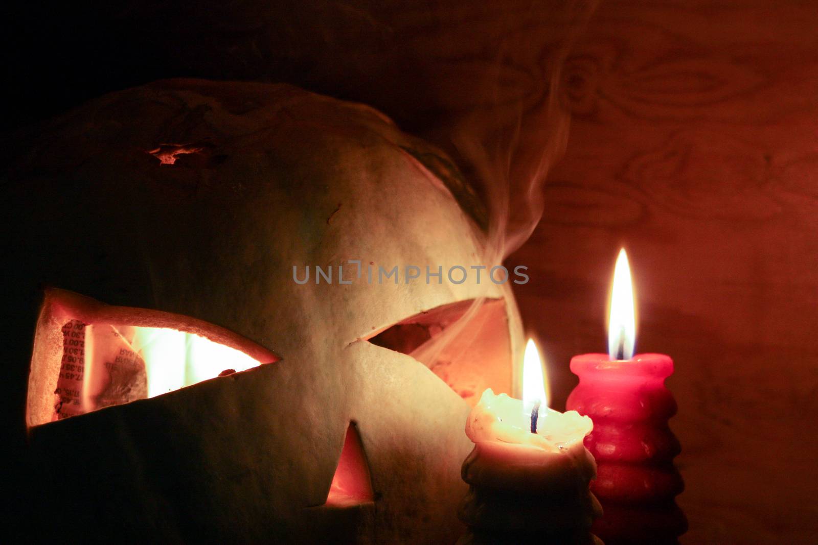 Halloween concept. The pumpkin smiling is burning in the fire. White smoke. Witchcraft and magic. Photo for your design