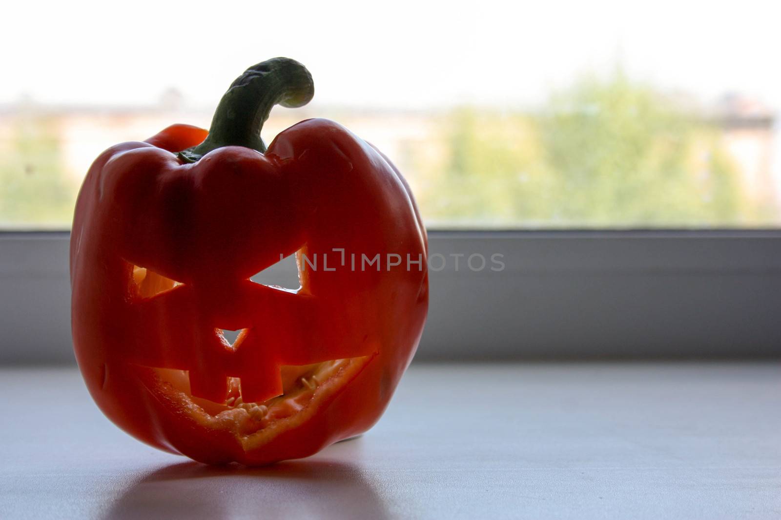 Halloween concept. Pumpkin on the window. Mask with an ugly face. Photo for your design