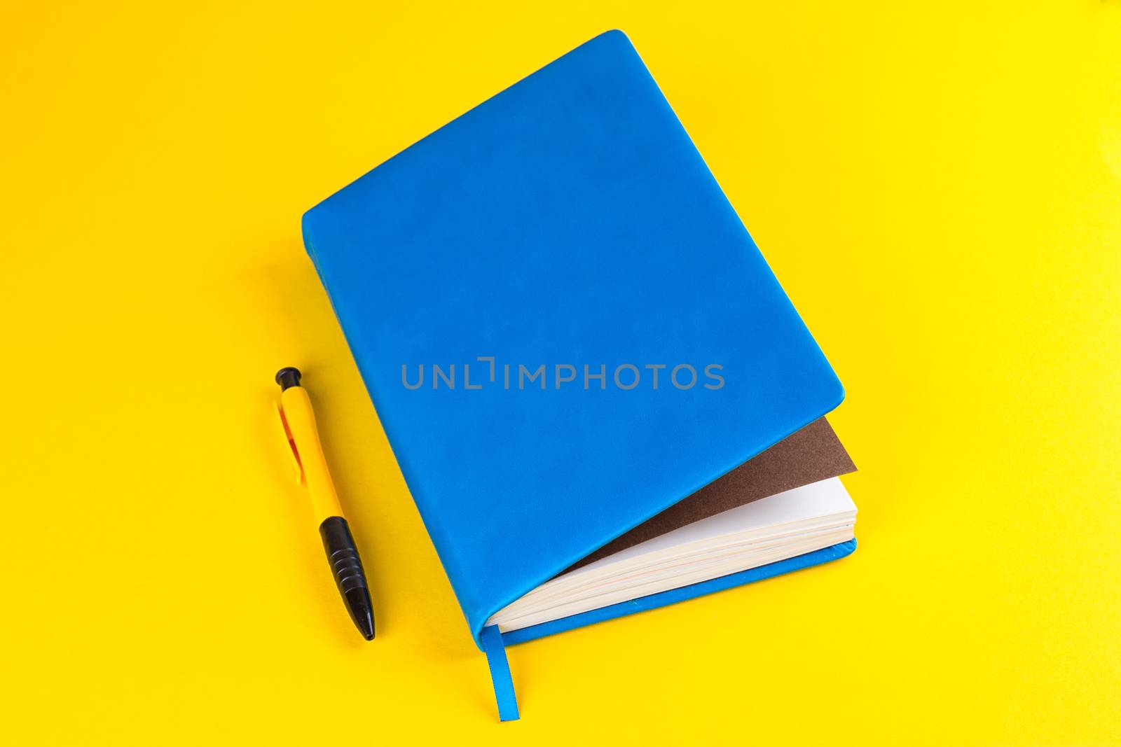 blue Daily planner with colored bookmarks. yellow background.