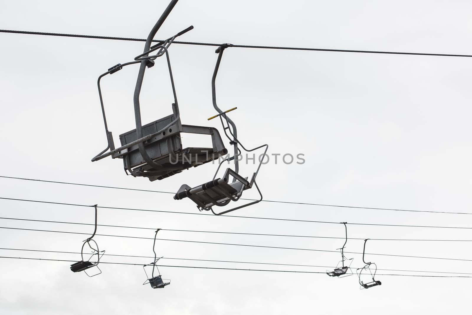 Empty chairlift with cloudy sky in the background by DmitrySteshenko